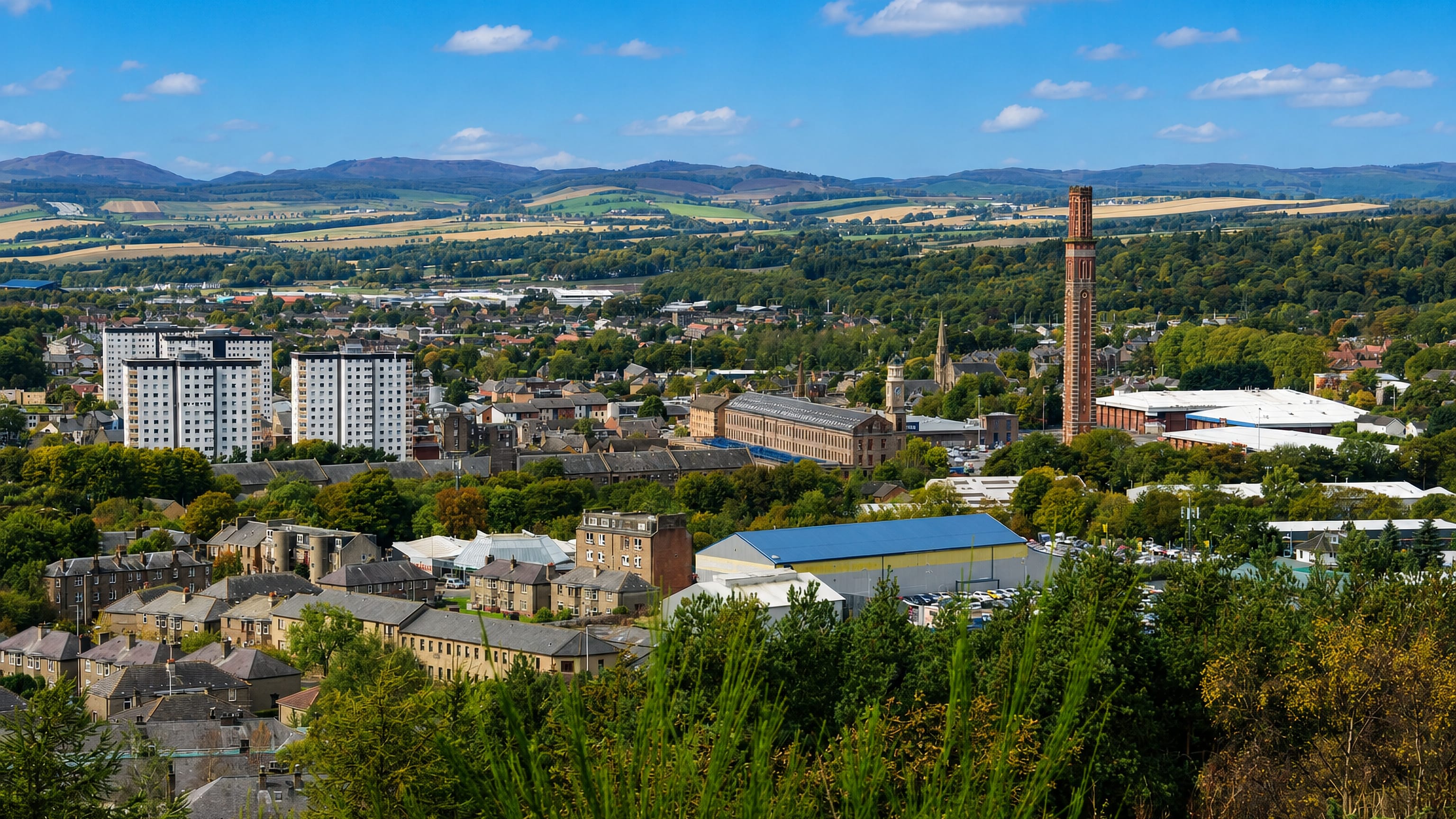 Lochee rooftops and the Cox's Stack mill chimney below the Sidlaw Hills in Dundee.
