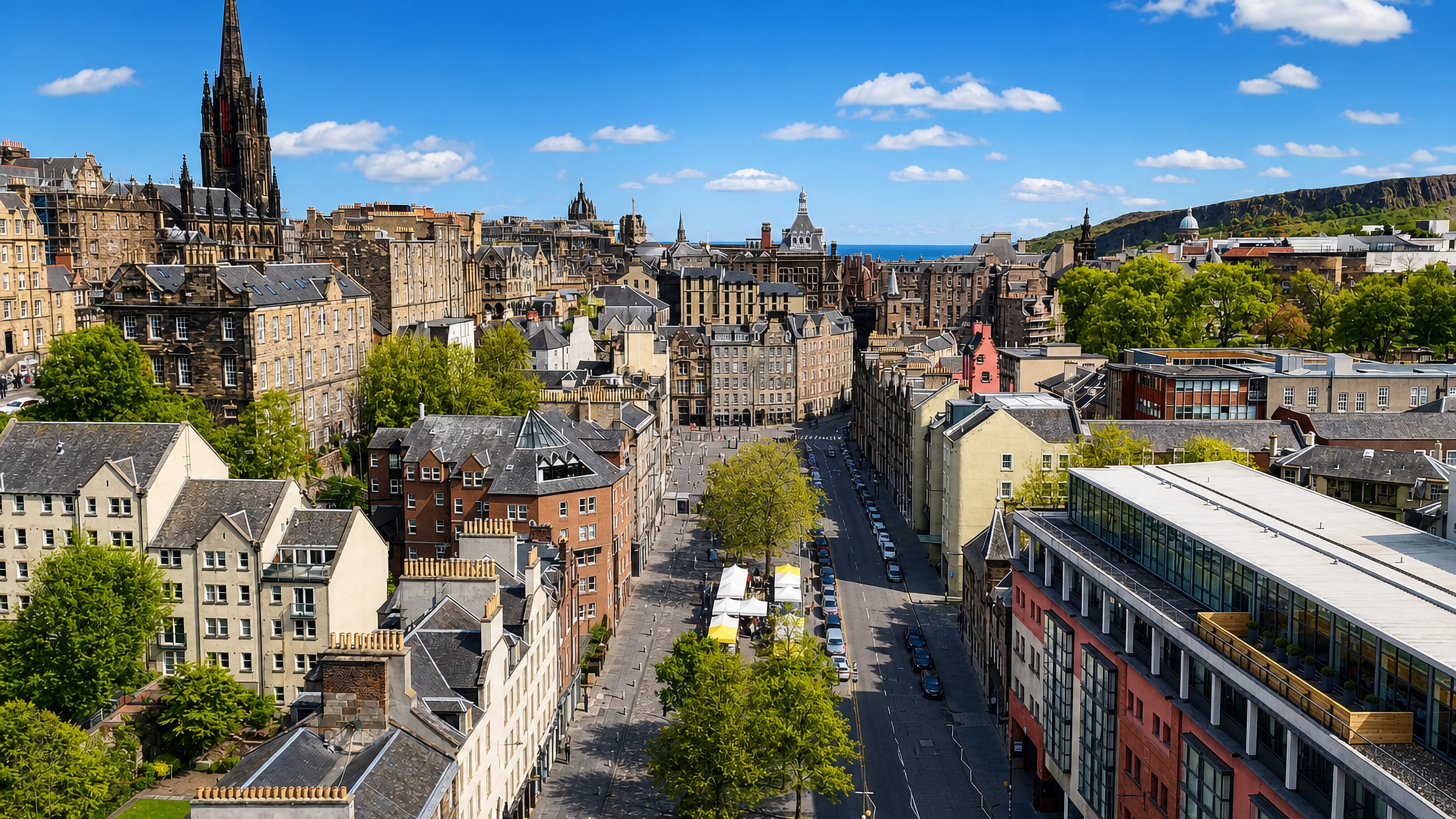Edinburgh's Grassmarket seen from above, market stalls and tenements below Old Town spires and the crags.