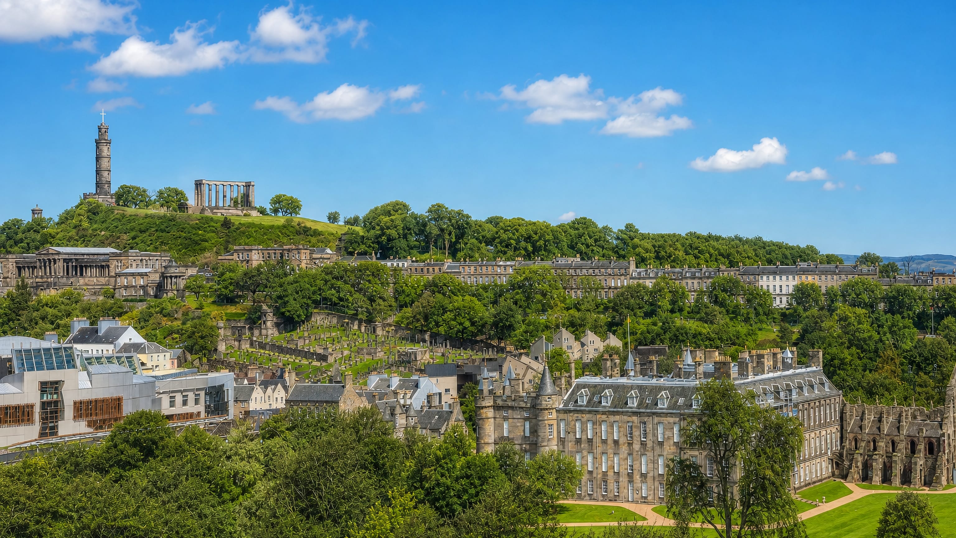 Holyrood Palace and the Scottish Parliament below Calton Hill's monuments and Georgian terraces in Edinburgh.