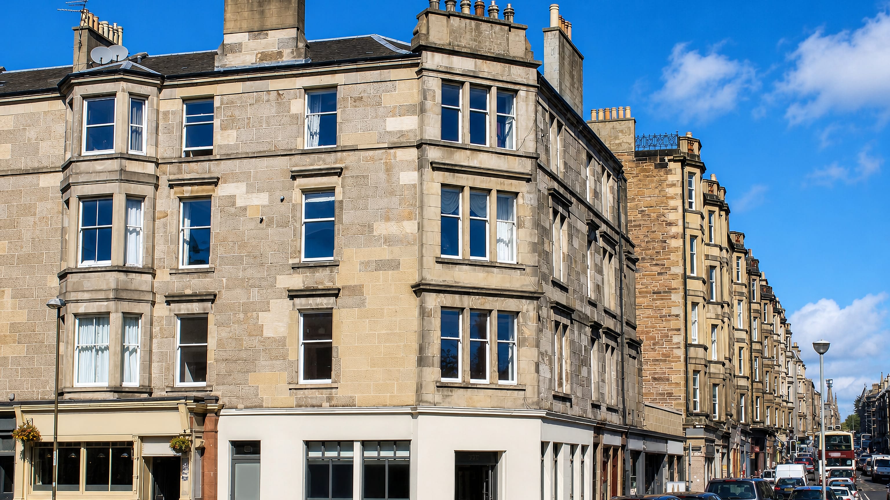 Victorian sandstone tenements with corner shops along a Morningside street in Edinburgh