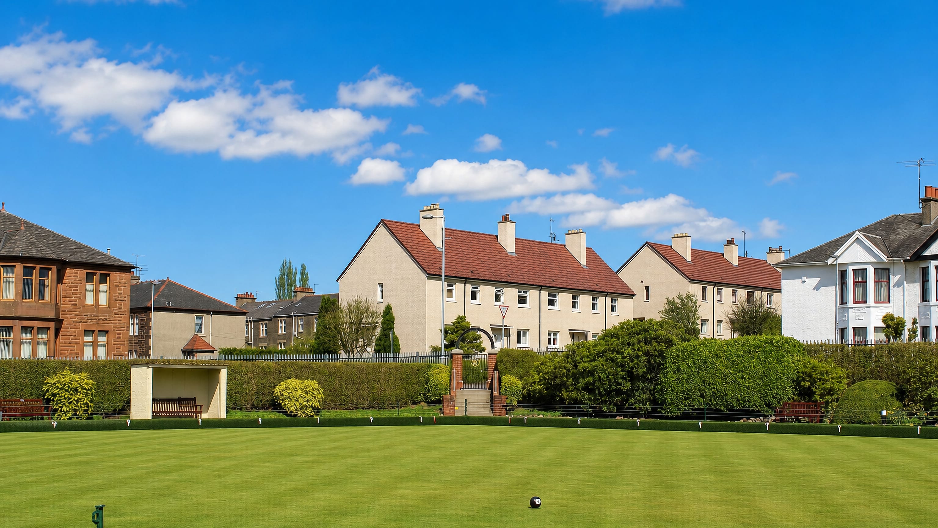 Bowling green backed by sandstone tenements and interwar houses in Cardonald, Glasgow.
