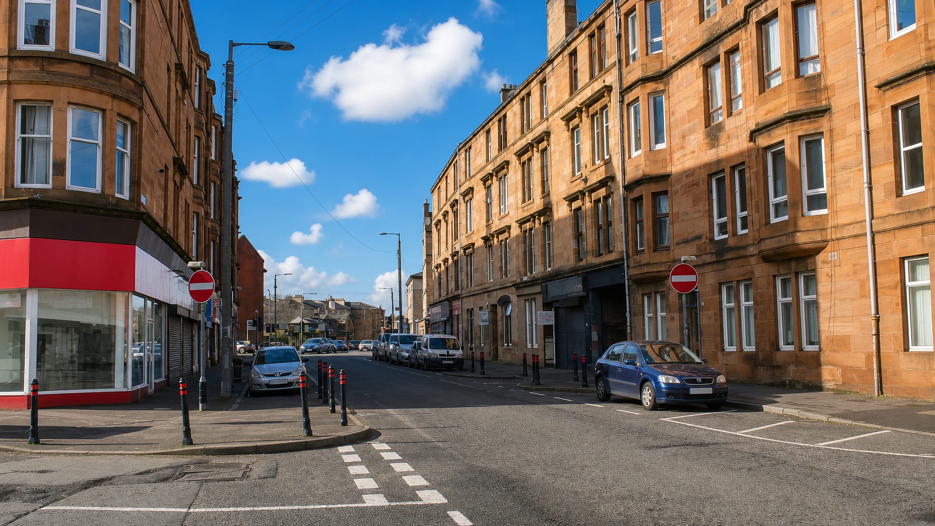 Sandstone tenements with bay windows lining a quiet street corner in Govanhill, Glasgow