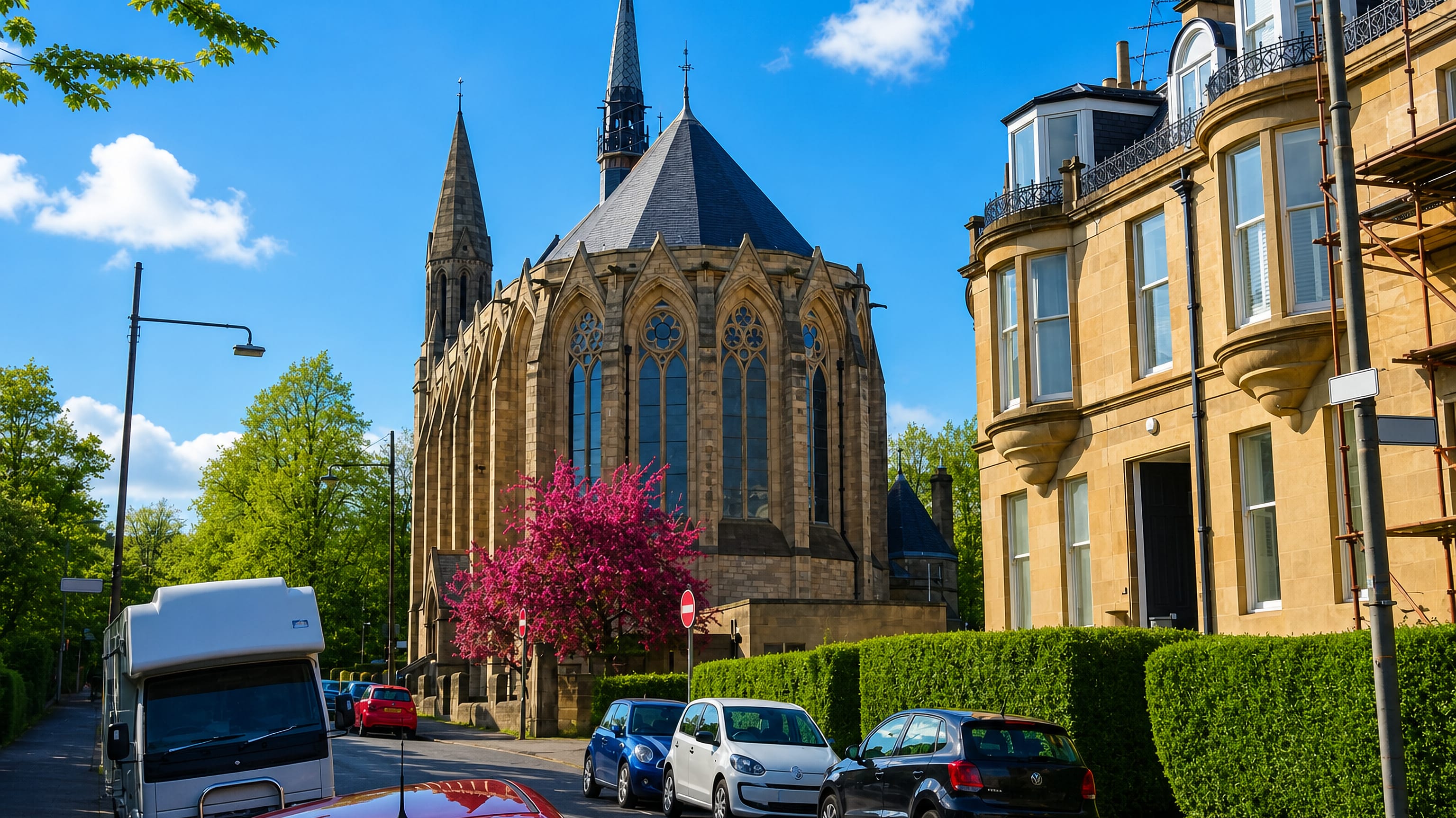 Blond sandstone terraces and a Gothic church spire on a tree-lined street in Kelvinside, Glasgow's West End.
