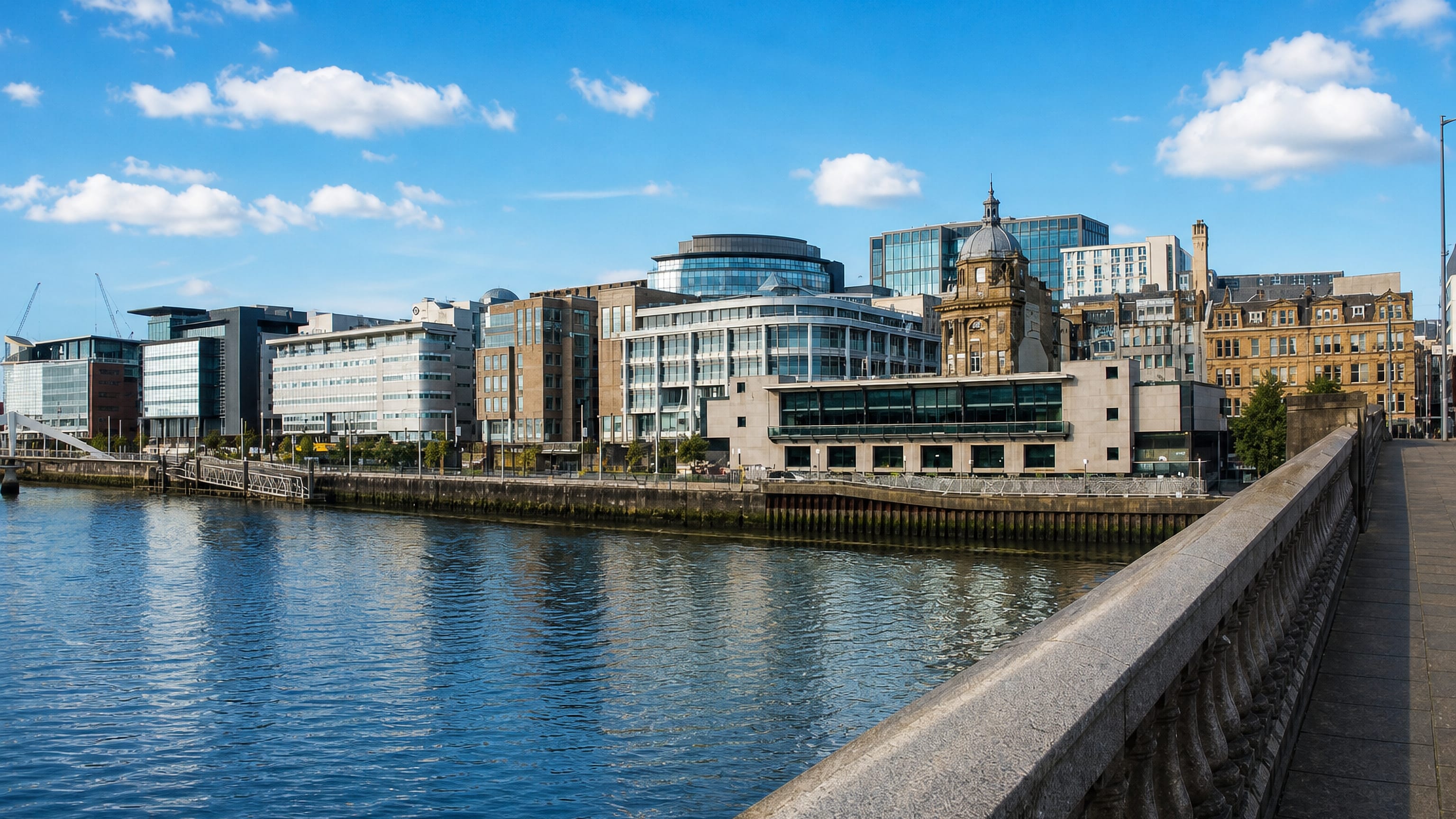 The River Clyde at Tradeston, Glasgow, with glass office blocks and the domed Clydeport building on the far bank.