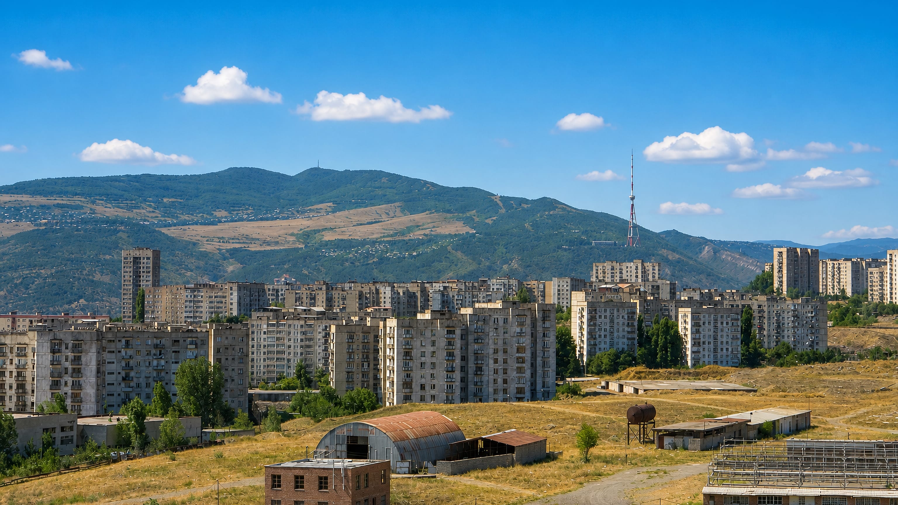 Soviet-era apartment blocks of Varketili, Tbilisi, with dry hills and the TV tower behind.