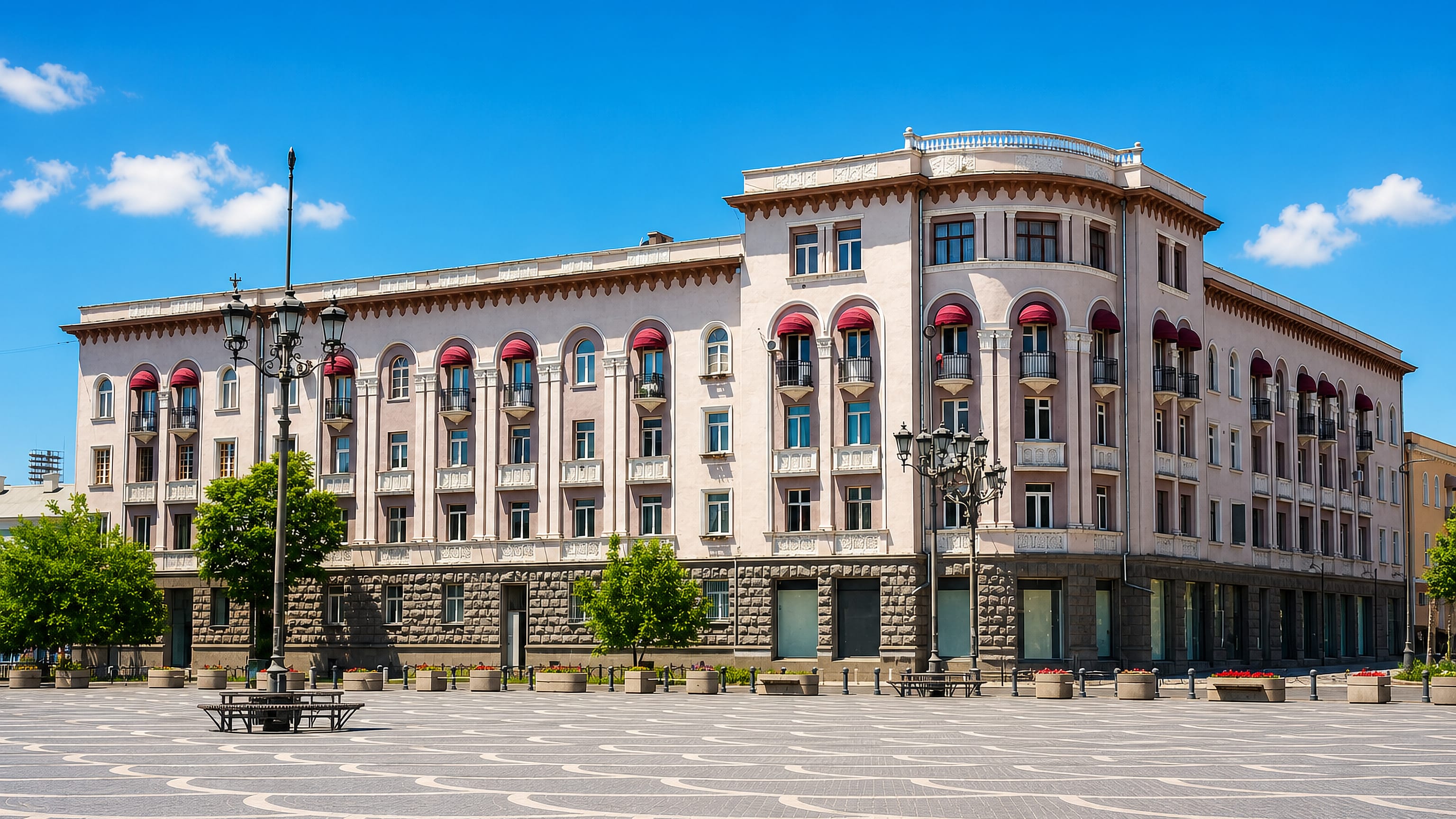 A Stalinist-era neoclassical block facing the patterned paving of a central square in Rustavi, Georgia.
