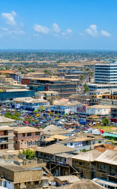 Aerial view of Accra's dense low-rise centre with a busy market and scattered mid-rise buildings