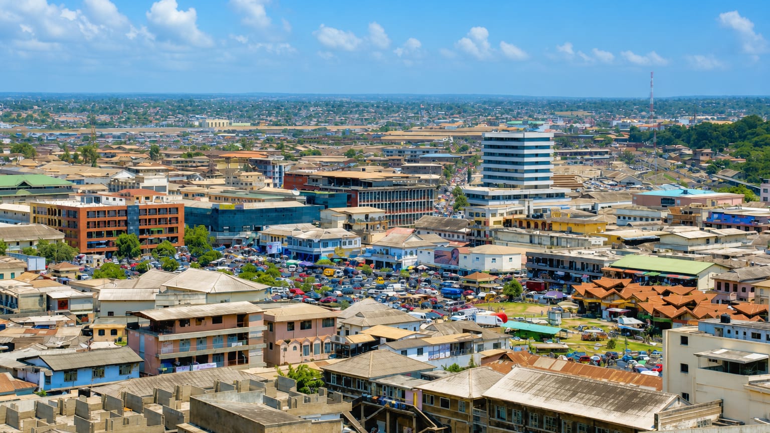 Aerial view of Accra's dense low-rise centre with a busy market and scattered mid-rise buildings