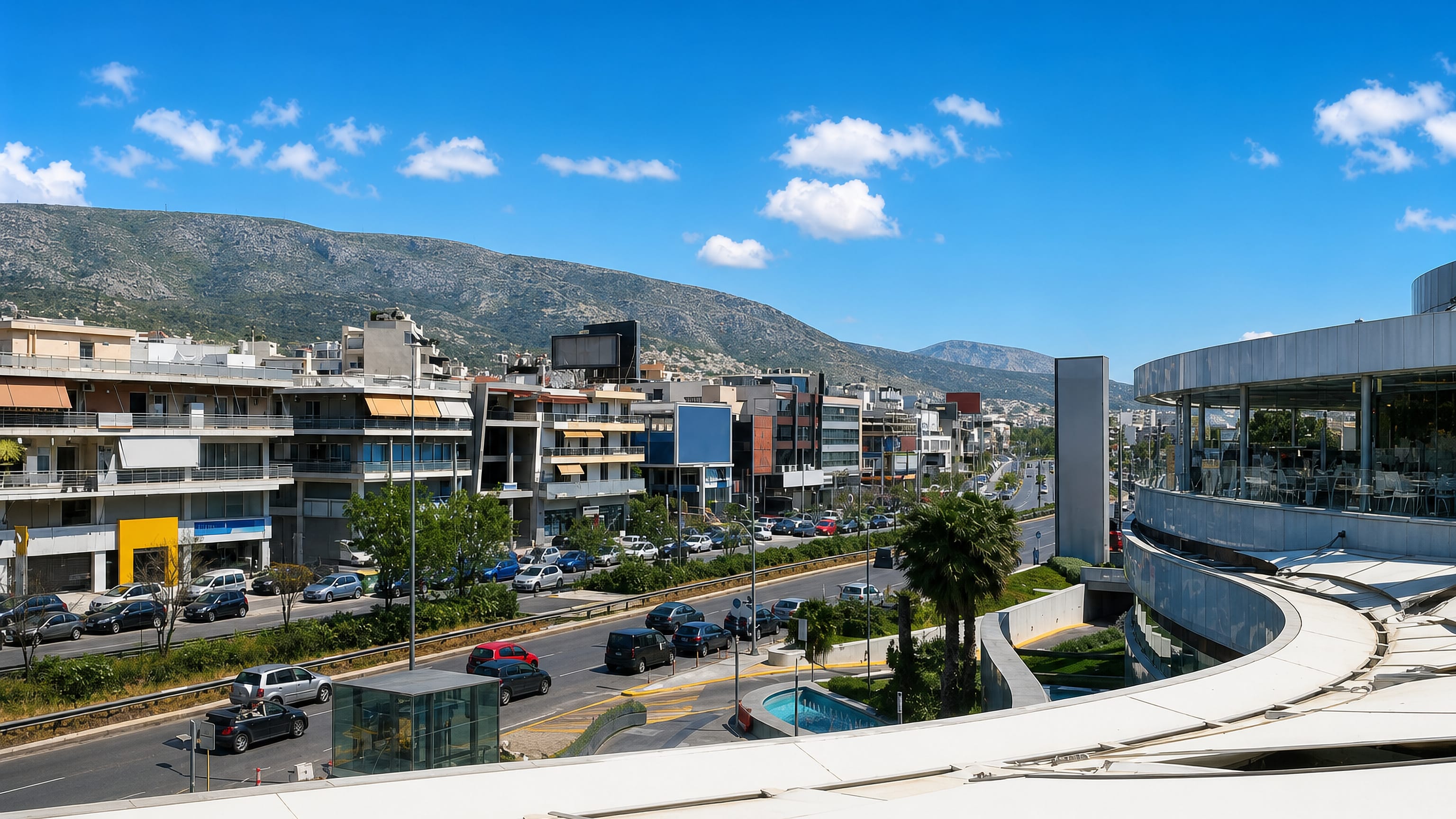 Apartment blocks and a busy avenue in Agios Dimitrios, Athens, below the dry ridge of Mount Hymettus.