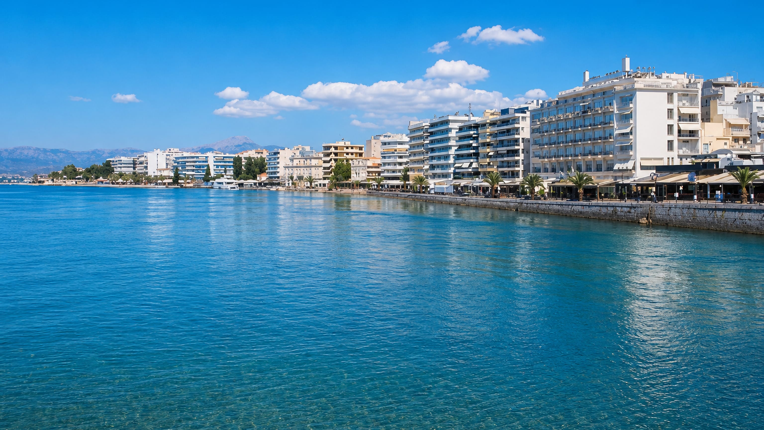 Chalkída's seafront promenade of white apartment blocks and cafés along the turquoise Euripus Strait