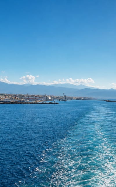Distant coastline and harbour breakwater of Heraklion seen across the sea, Crete, Greece