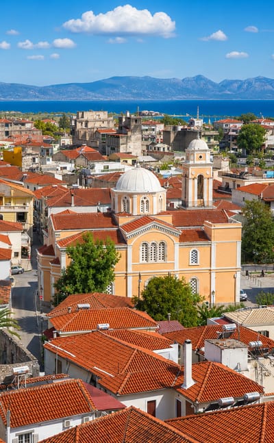 Red-tiled rooftops and the domed Ypapanti church of Kalamata above the Messinian Gulf.