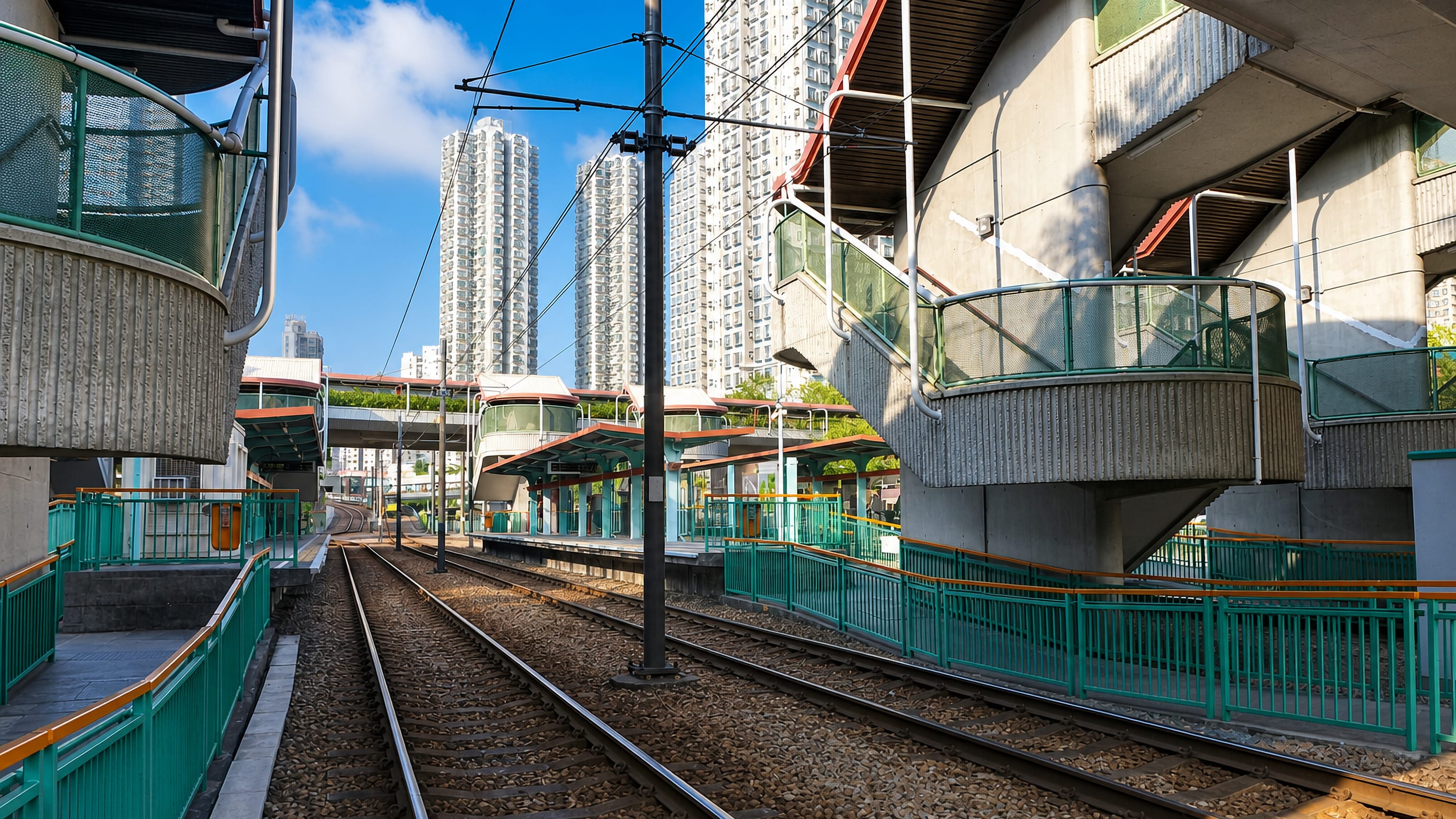 Light rail tracks and platforms beneath high-rise housing towers in Tuen Mun, Hong Kong.
