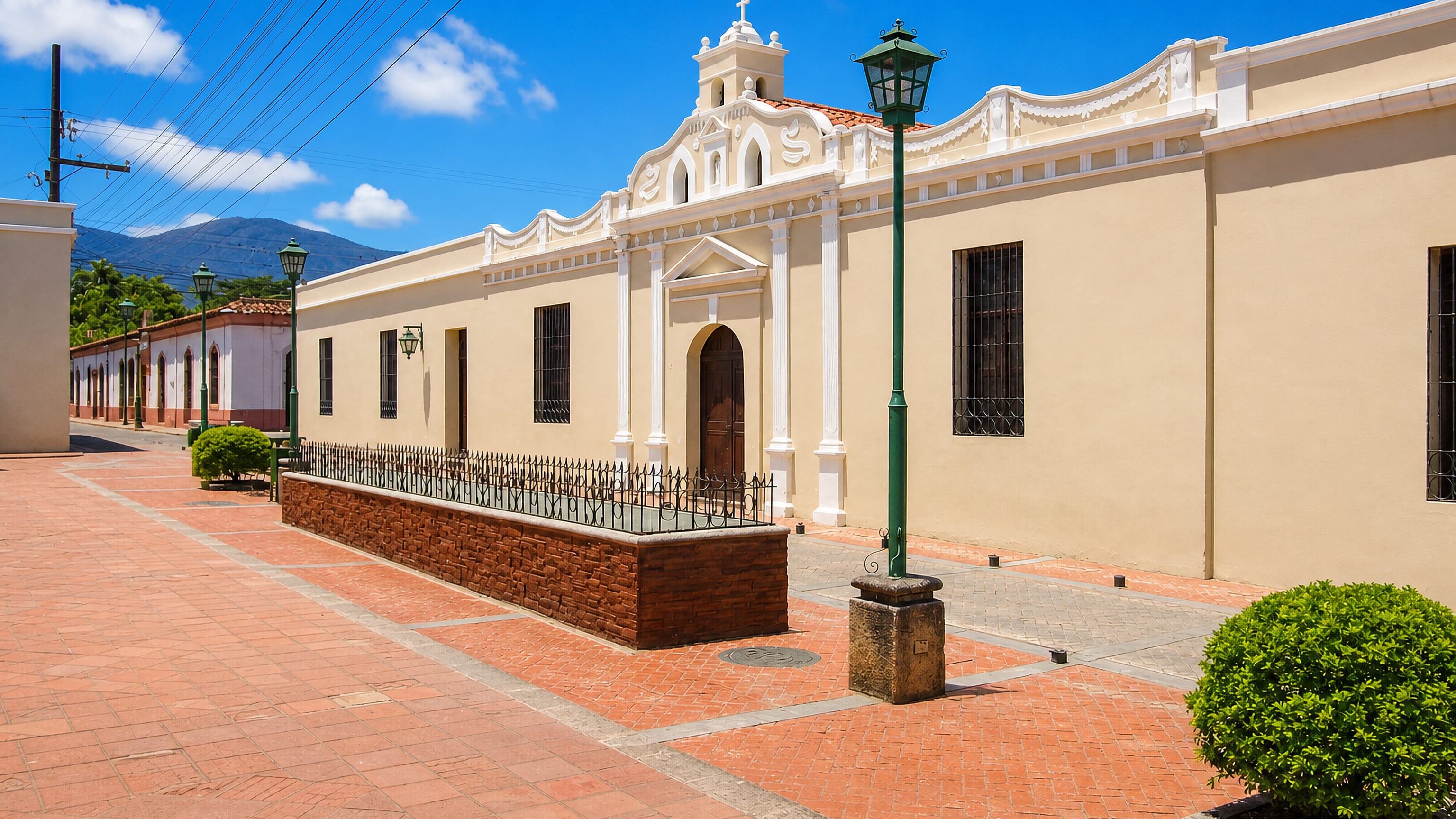 Colonial church and brick-paved plaza in the restored historic centre of Comayagua, Honduras, with hills behind.