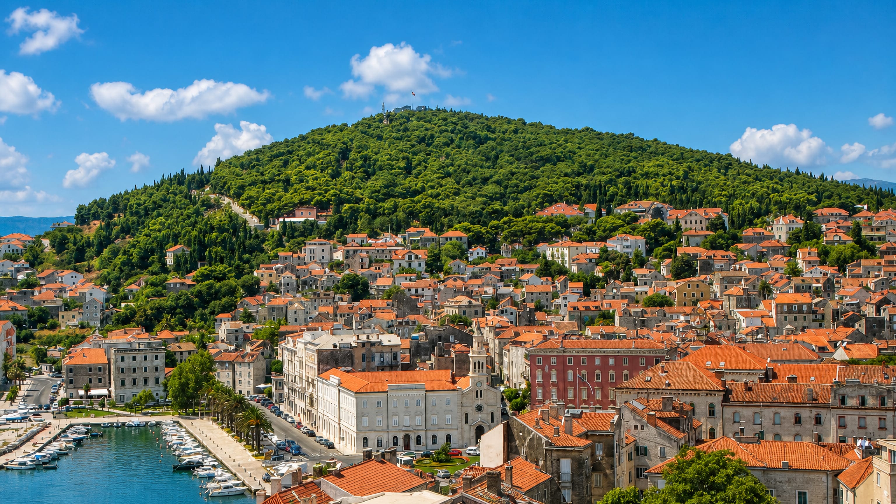 Varos, Split: stone houses with terracotta roofs climbing Marjan hill above the harbour and marina.