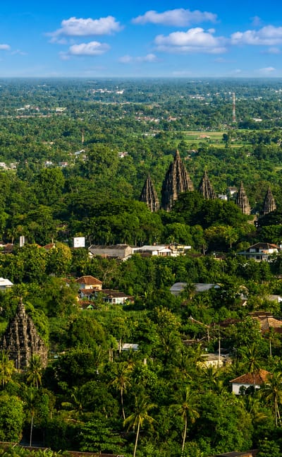 Prambanan temple spires rising above palm groves and villages on the plain near Yogyakarta