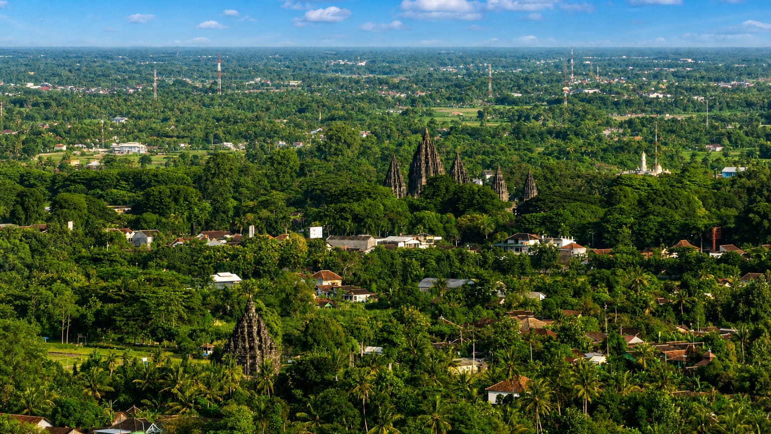 Prambanan temple spires rising above palm groves and villages on the plain near Yogyakarta