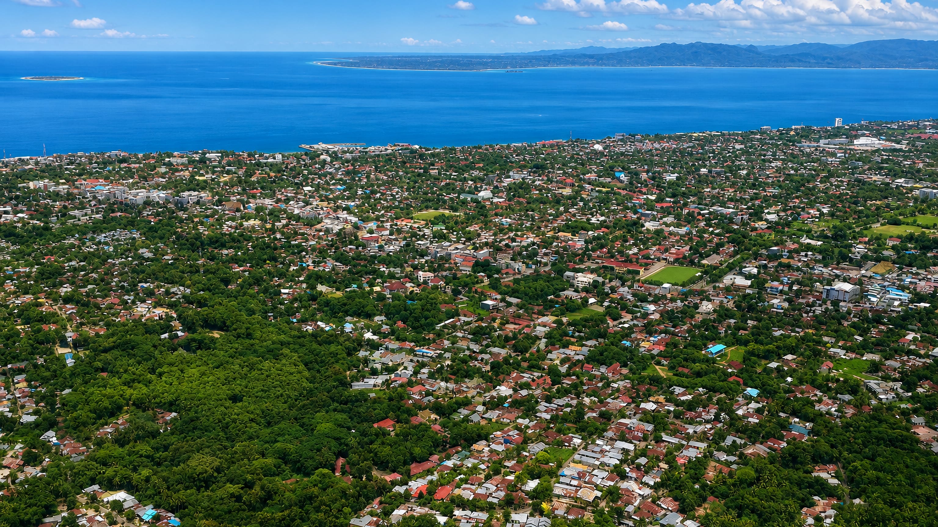Aerial view over the low-rise tropical sprawl of Kupang, Indonesia, facing Kupang Bay and offshore islands