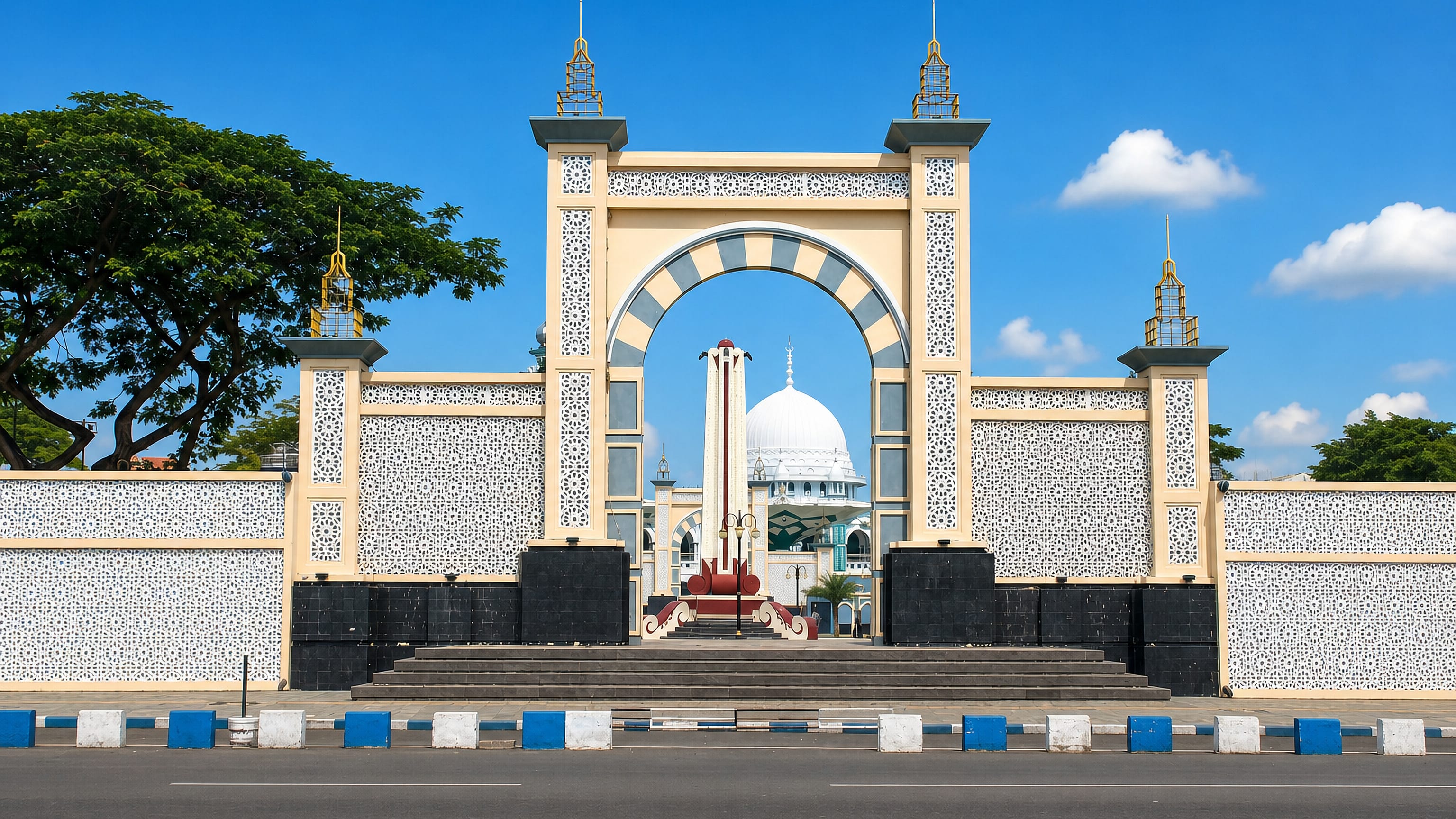 Ornate ceremonial gateway framing the white-domed grand mosque on the alun-alun of Pasuruan, East Java
