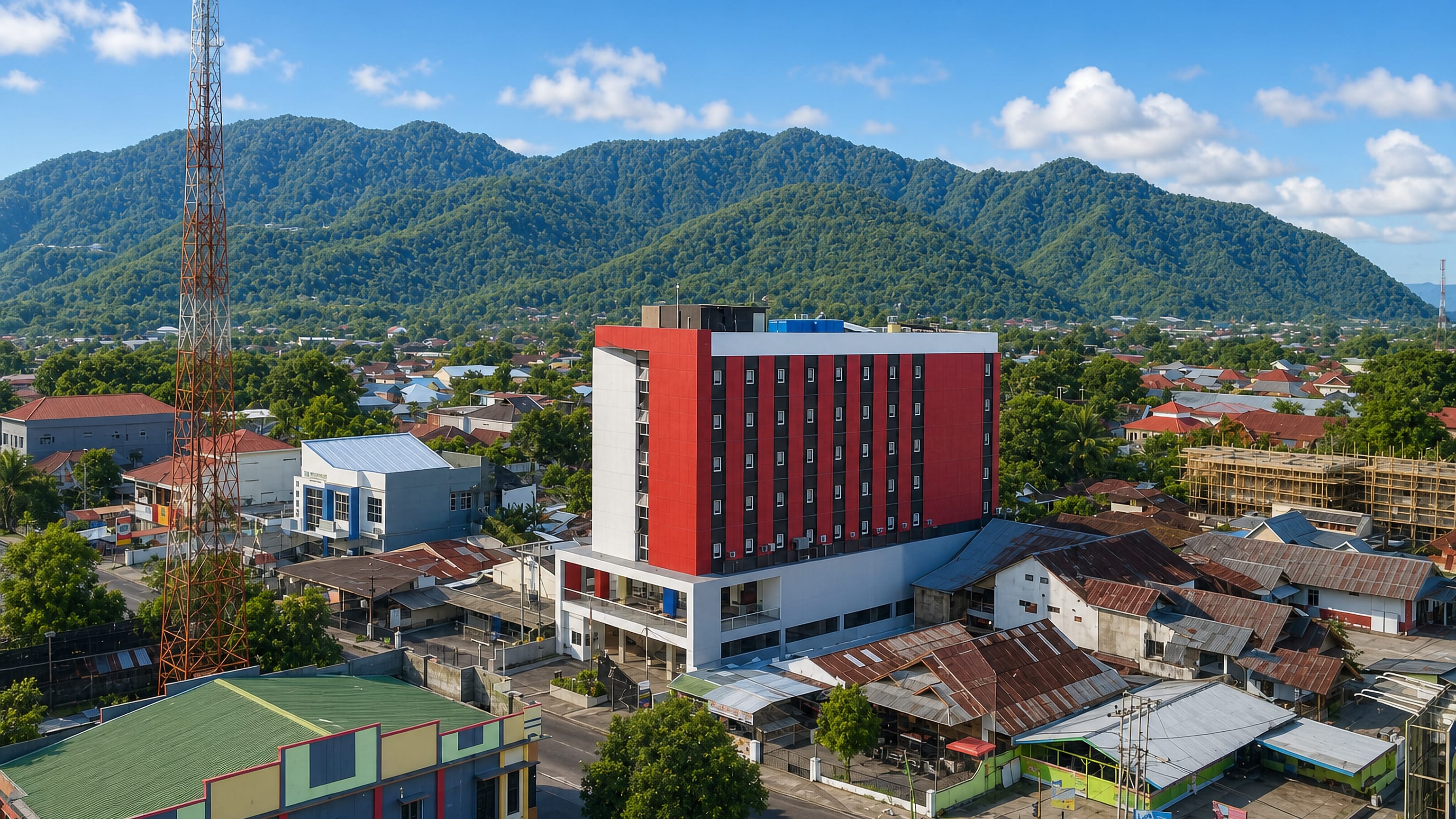 Aerial view of Gorontalo's low-rise centre in Sulawesi, red-roofed houses below forested mountains