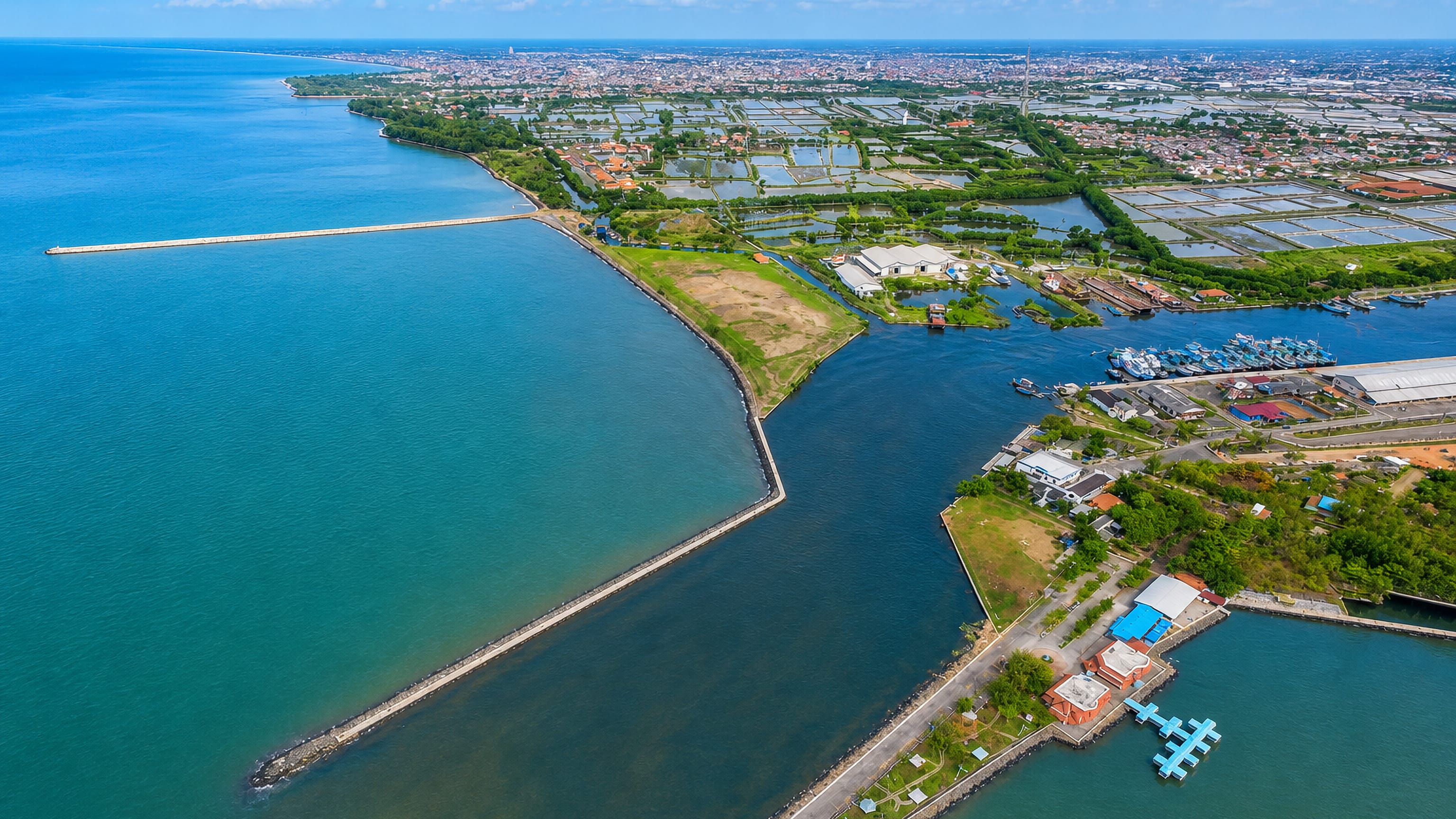 Aerial view of Pekalongan's harbour mouth, breakwaters and coastal fish ponds on Java's north coast.