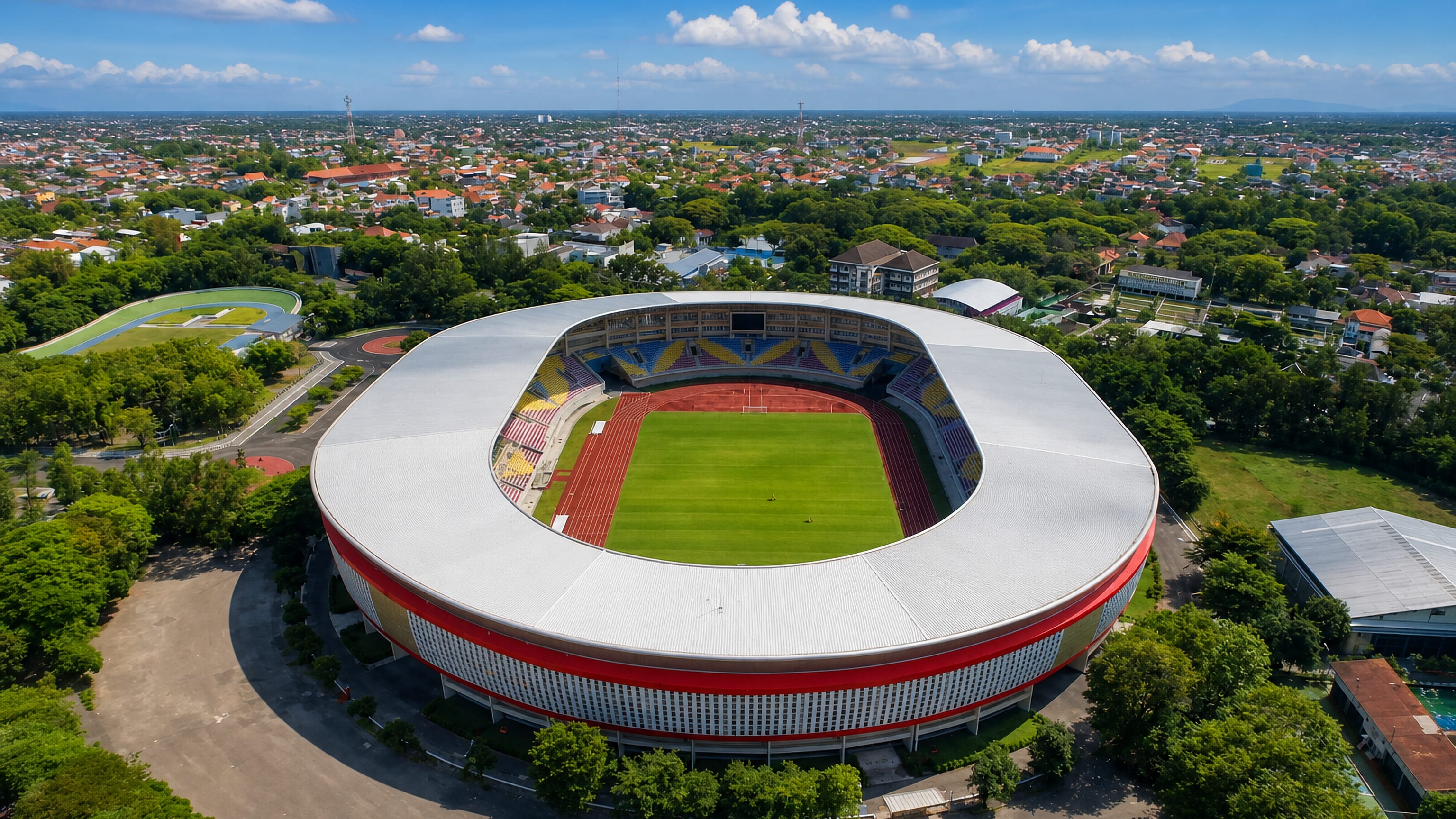 Aerial view of Manahan Stadium ringed by the rooftops and treed suburbs of Surakarta, Central Java.