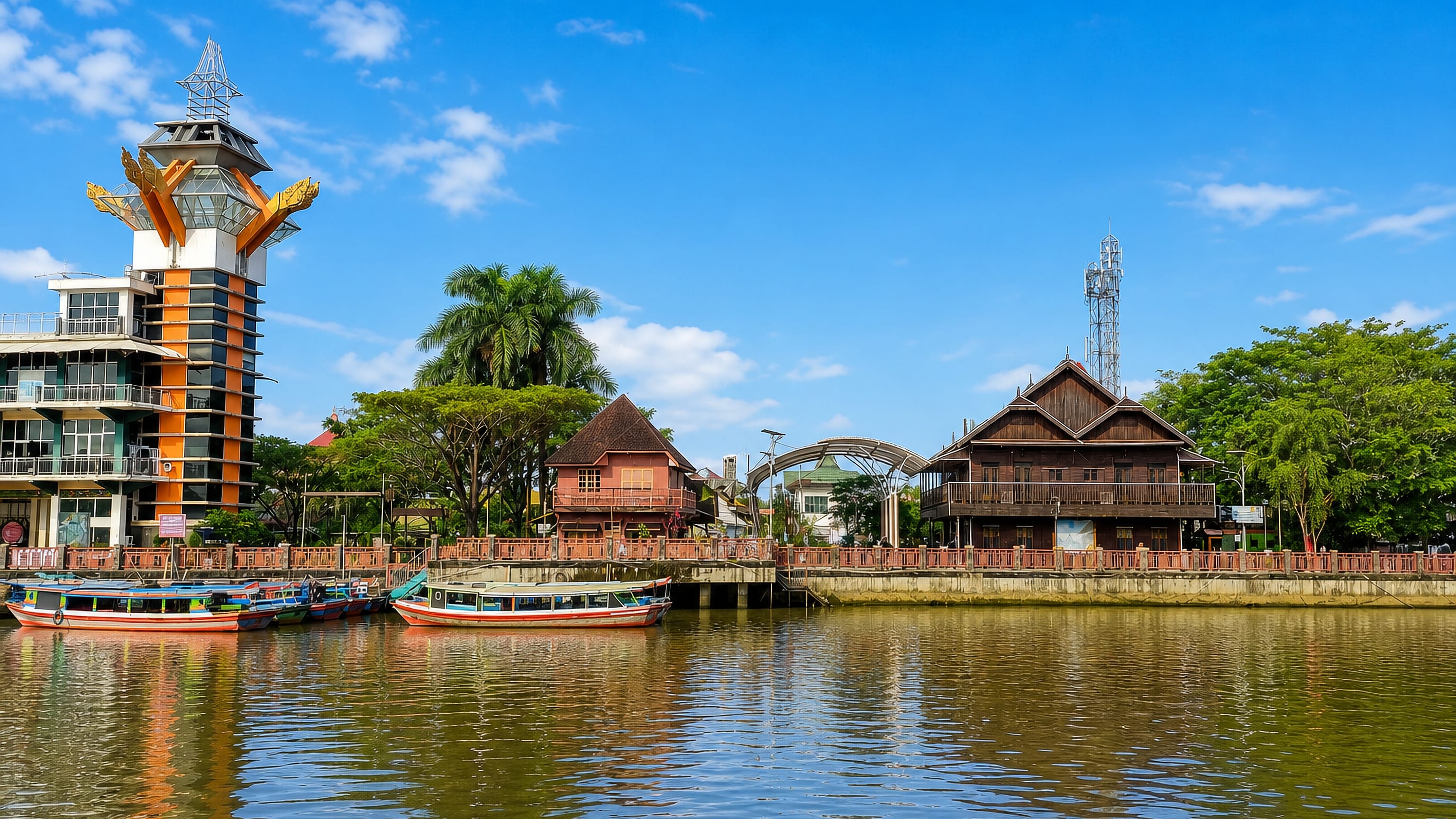 Banjarmasin, Indonesia: a riverside observation tower, a wooden Banjar house and klotok boats on the river.