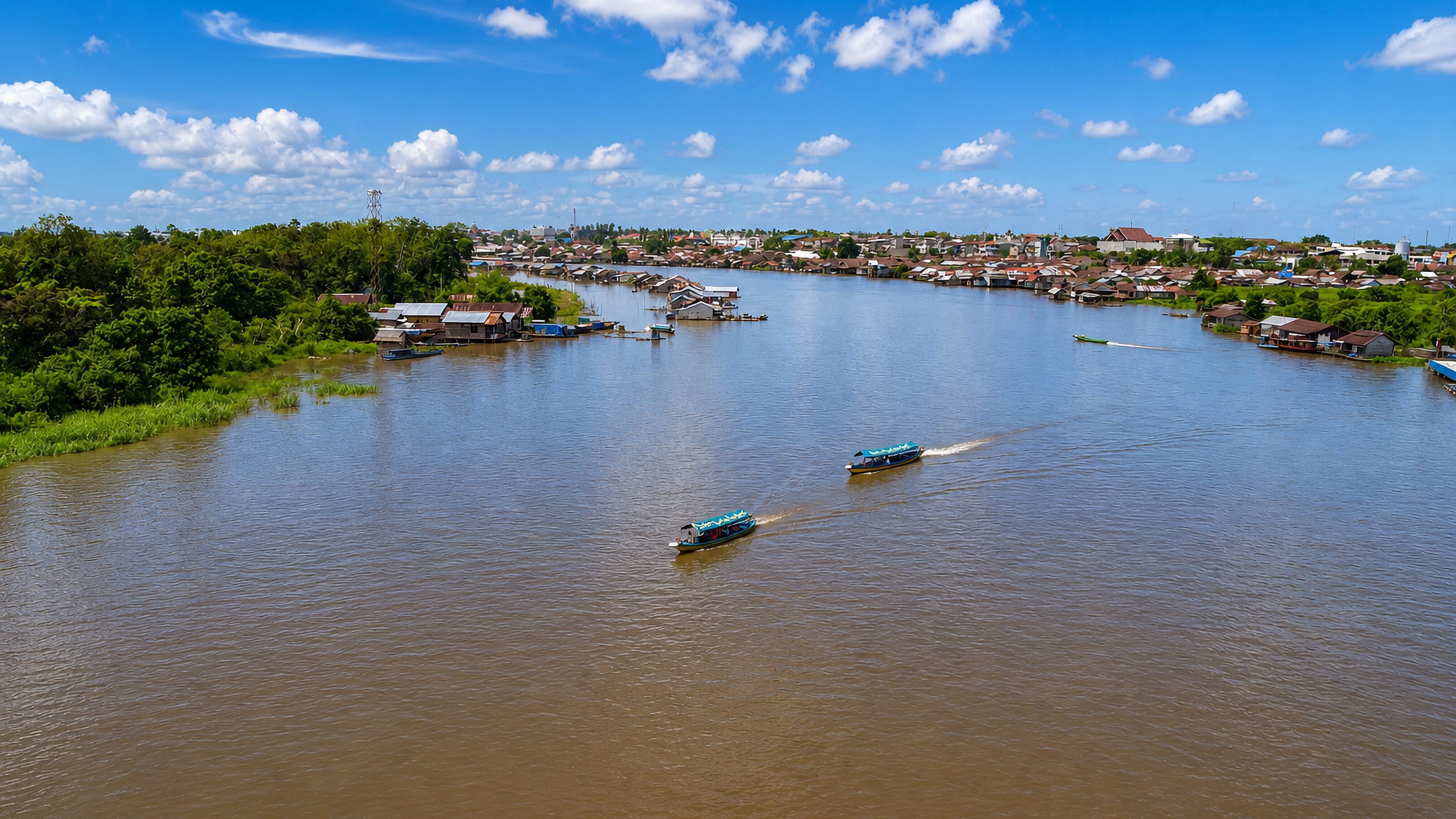 Wooden boats on the broad Kahayan River at Palangkaraya, with stilt houses lining both banks.