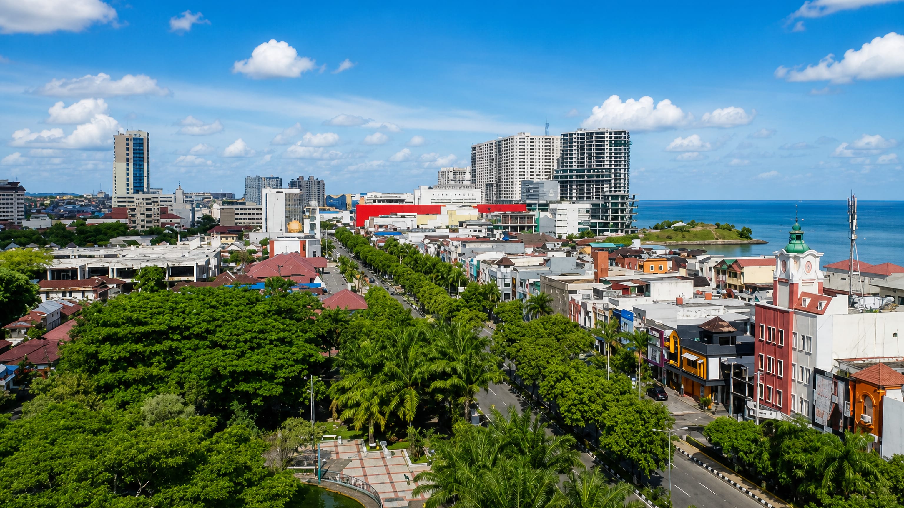 Balikpapan's tree-lined coastal boulevard and mid-rise skyline above the Makassar Strait on a clear day