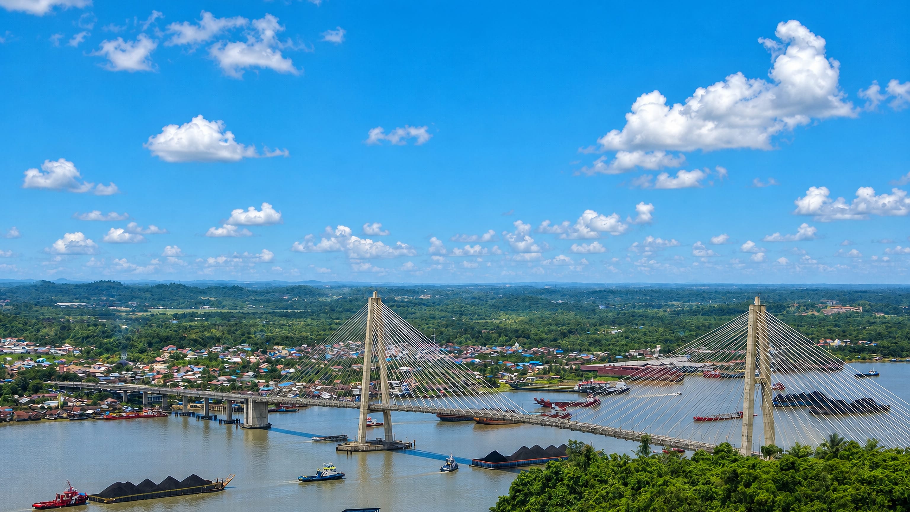 A cable-stayed bridge spanning the Mahakam River at Samarinda, Indonesia, with coal barges under tow