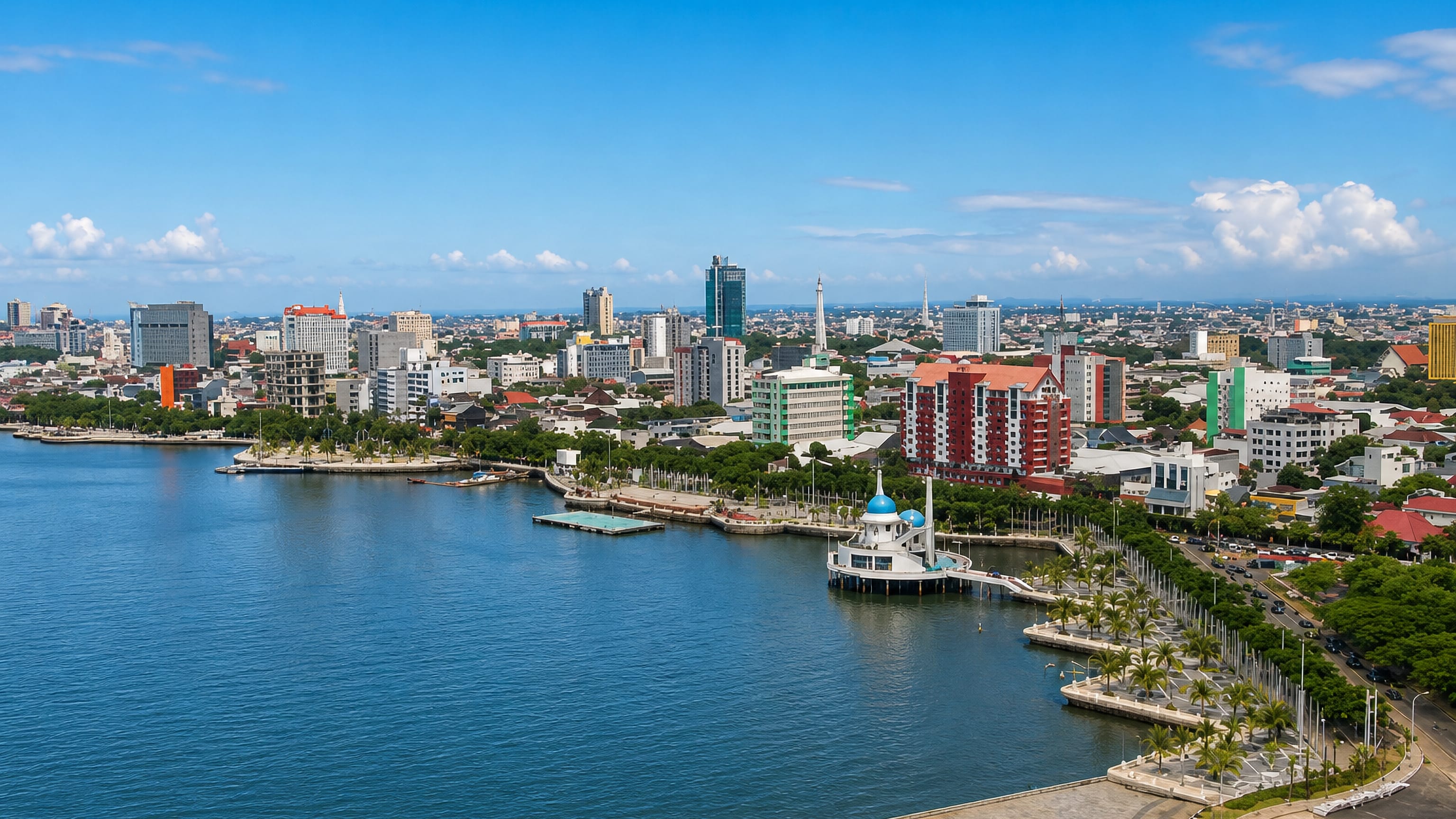 Makassar's Losari Beach waterfront on the Makassar Strait, with the blue-domed floating mosque and city skyline.