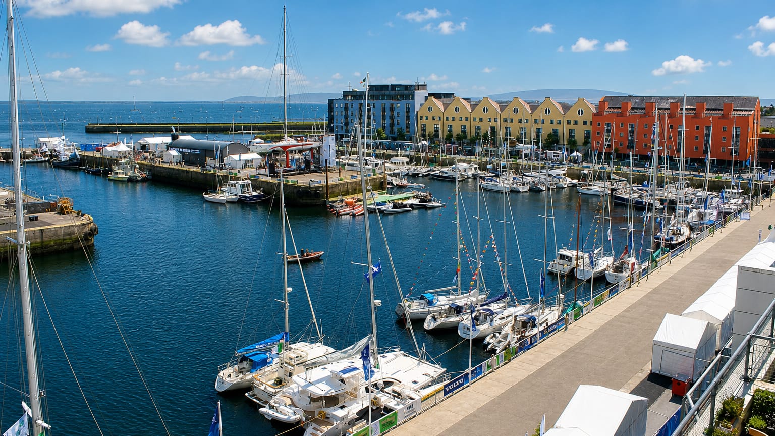 Galway's harbour marina filled with yachts beside yellow gabled dock warehouses during a sailing event