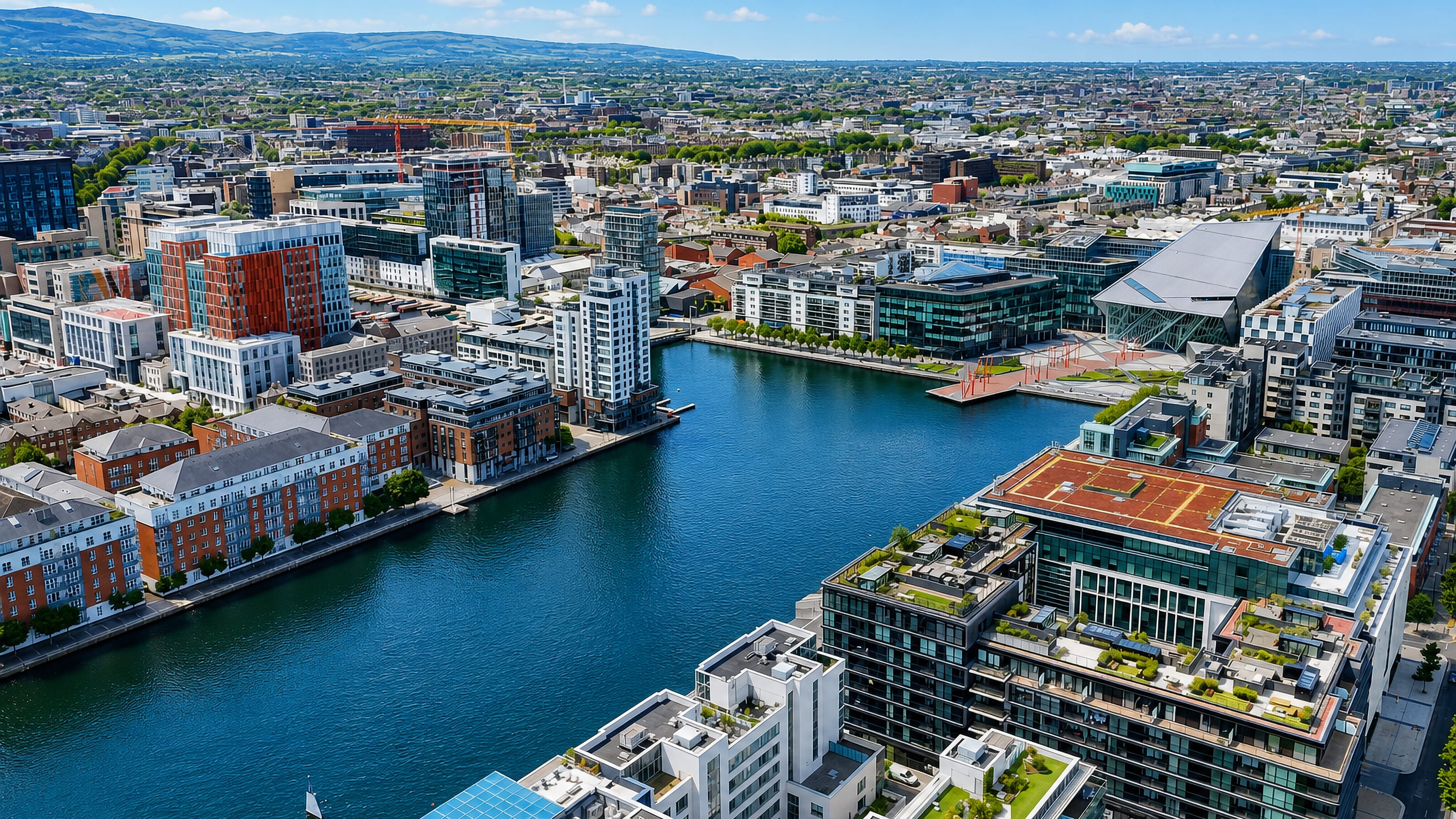 Aerial view of Grand Canal Dock in Dublin, its basin ringed by modern offices and apartment blocks.