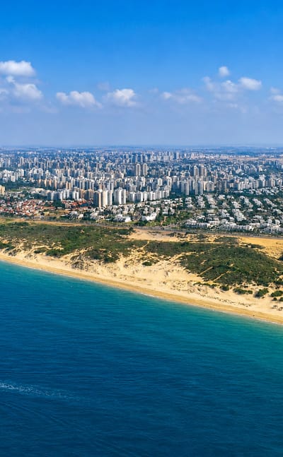 Aerial view of Ashdod, Israel, showing its Mediterranean beach, dunes, and white coastal skyline.