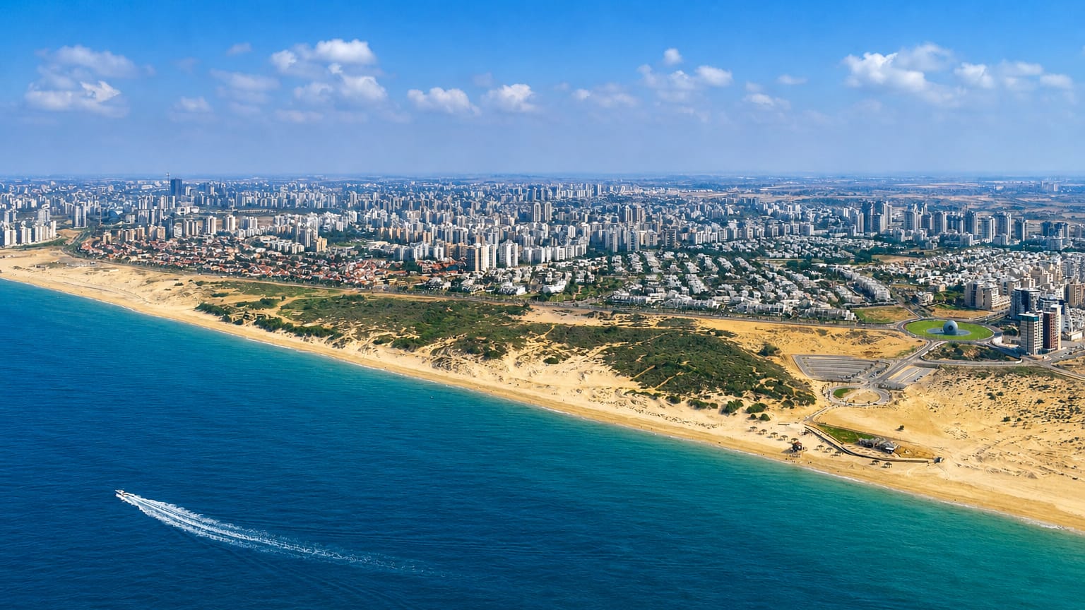 Aerial view of Ashdod, Israel, showing its Mediterranean beach, dunes, and white coastal skyline.