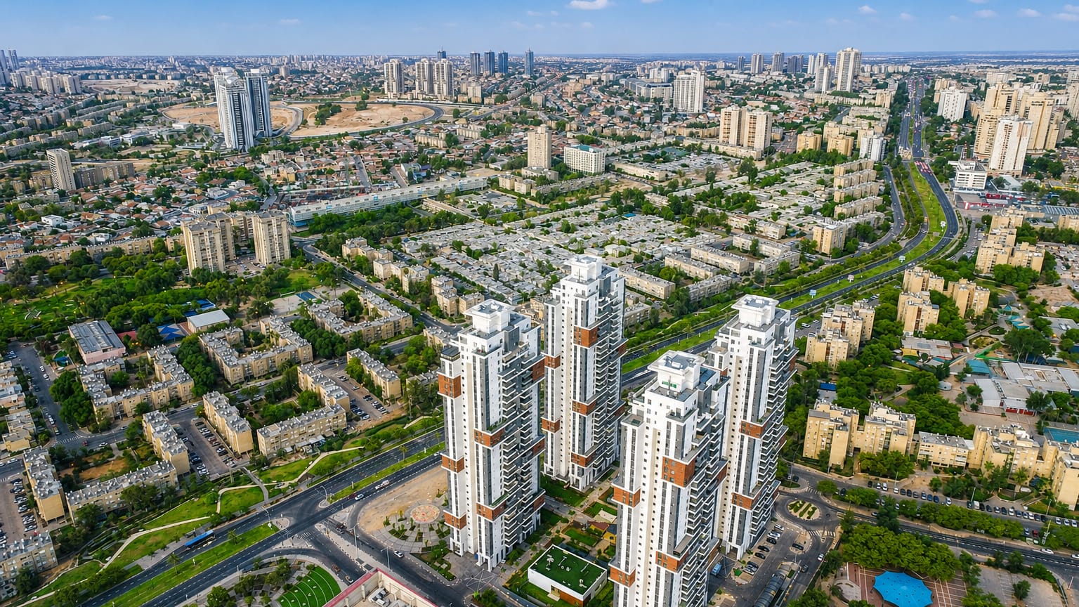 Aerial of Beersheba with its cluster of white residential towers amid desert-edge apartment blocks.