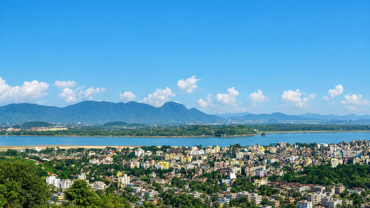 Guwahati spreading along the wide Brahmaputra River below forested hills in Assam, India.