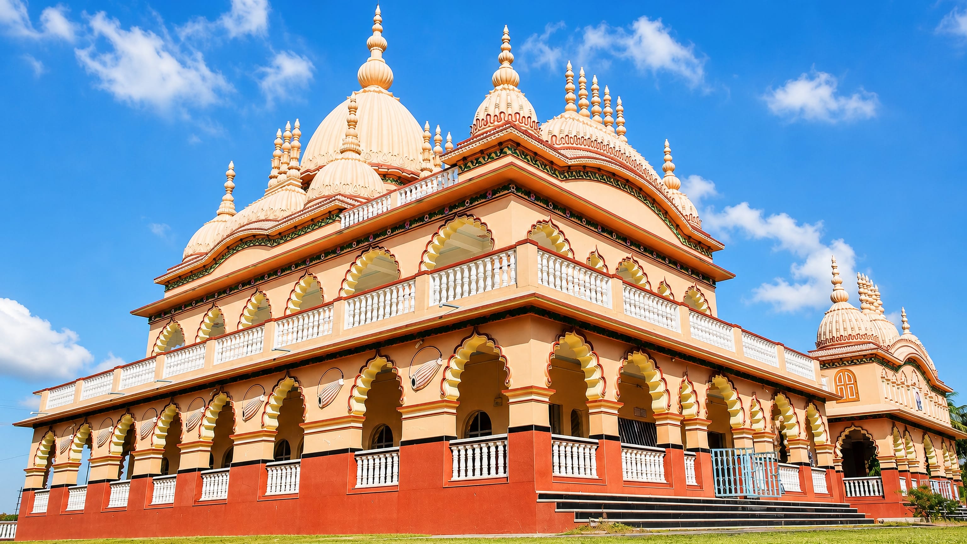 Ornate cream-domed Hindu temple with arched verandas and lawns on the edge of Jorhat, Assam.