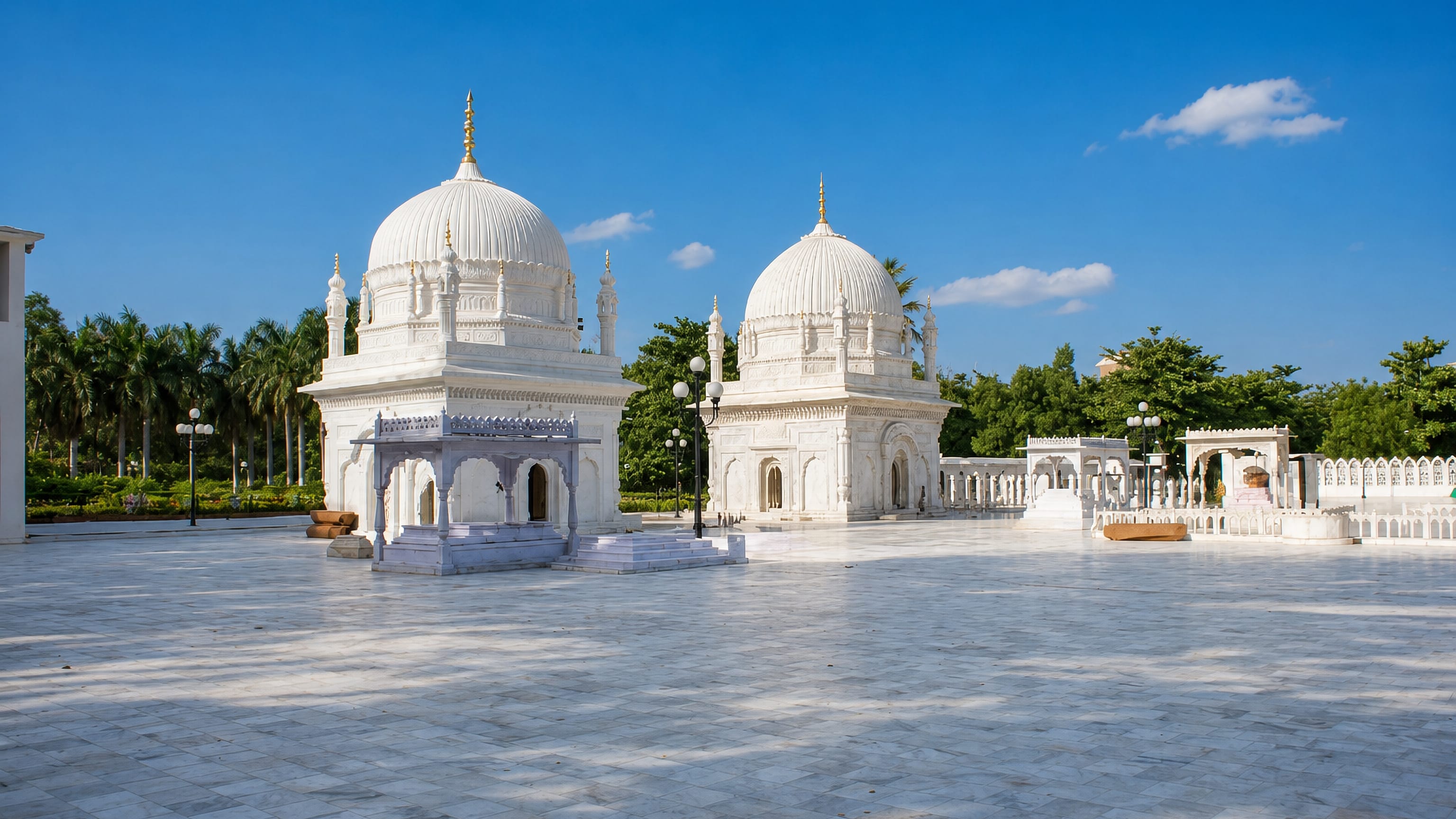 White marble domed pavilions on the polished courtyard of a shrine complex in Burhānpur, India.
