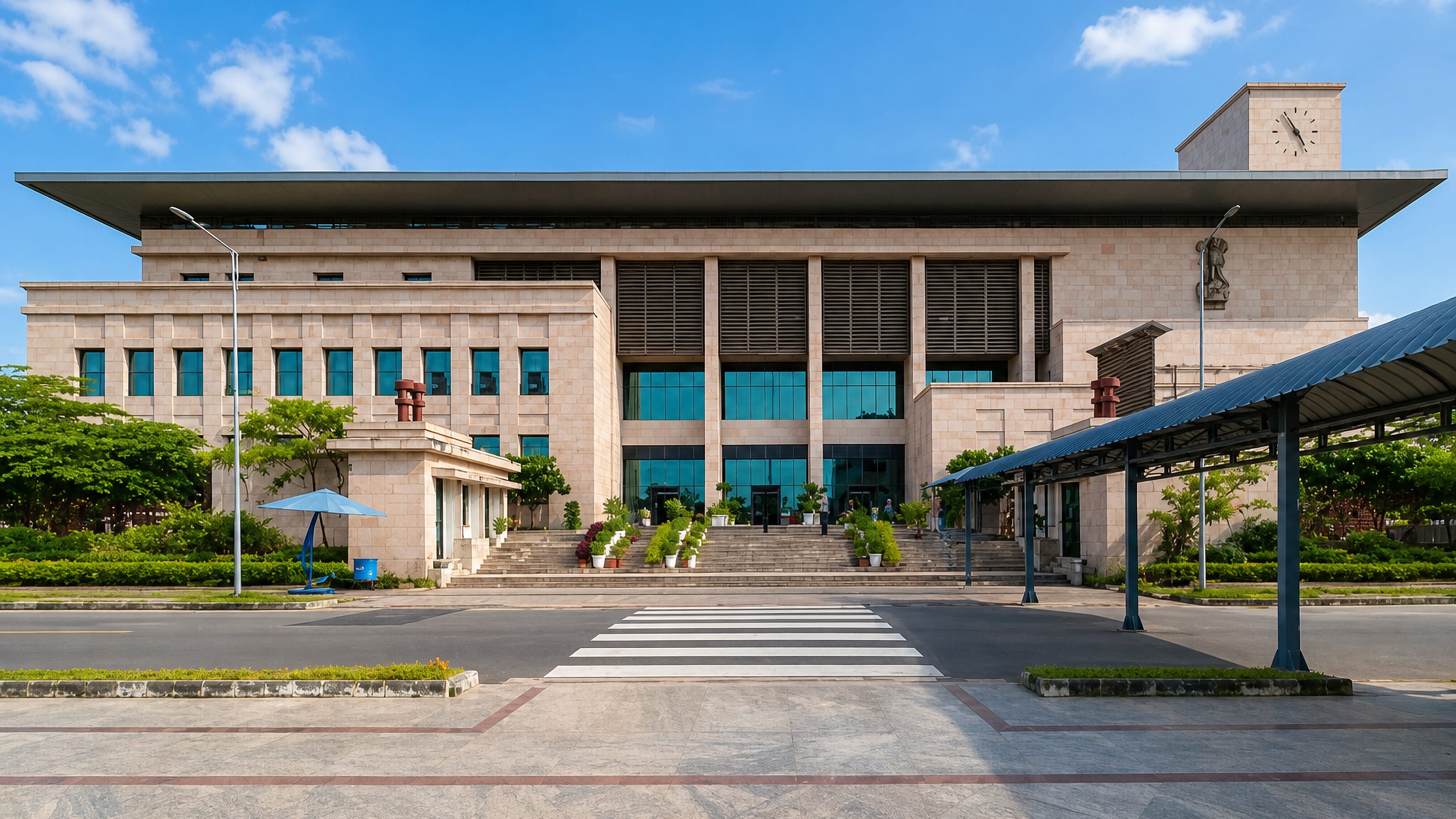Modern stone government building with a clock tower and covered walkway in Amaravati, Andhra Pradesh.