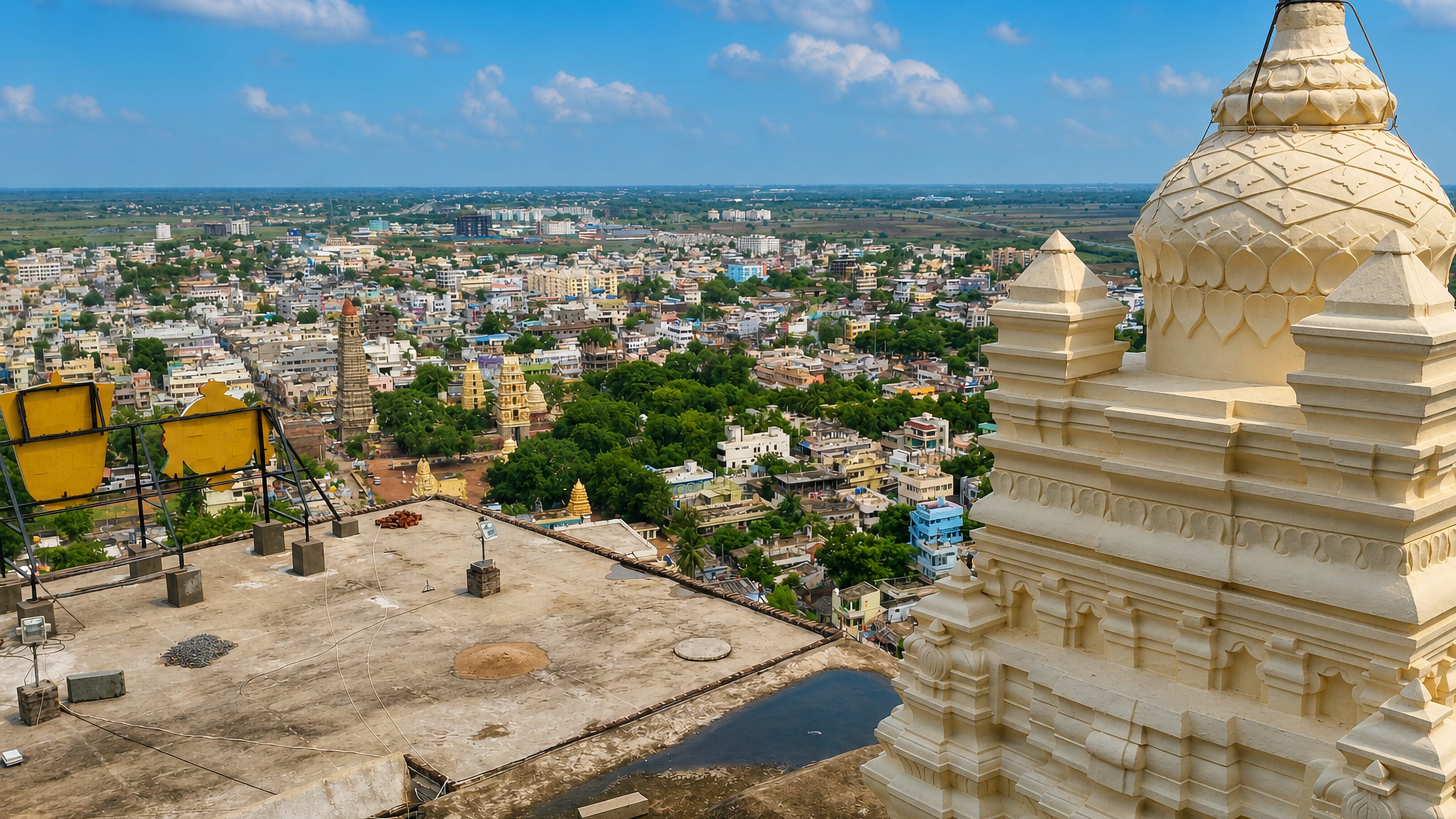 Mangalagiri's rooftops and temple gopurams viewed from a white temple tower in Andhra Pradesh.