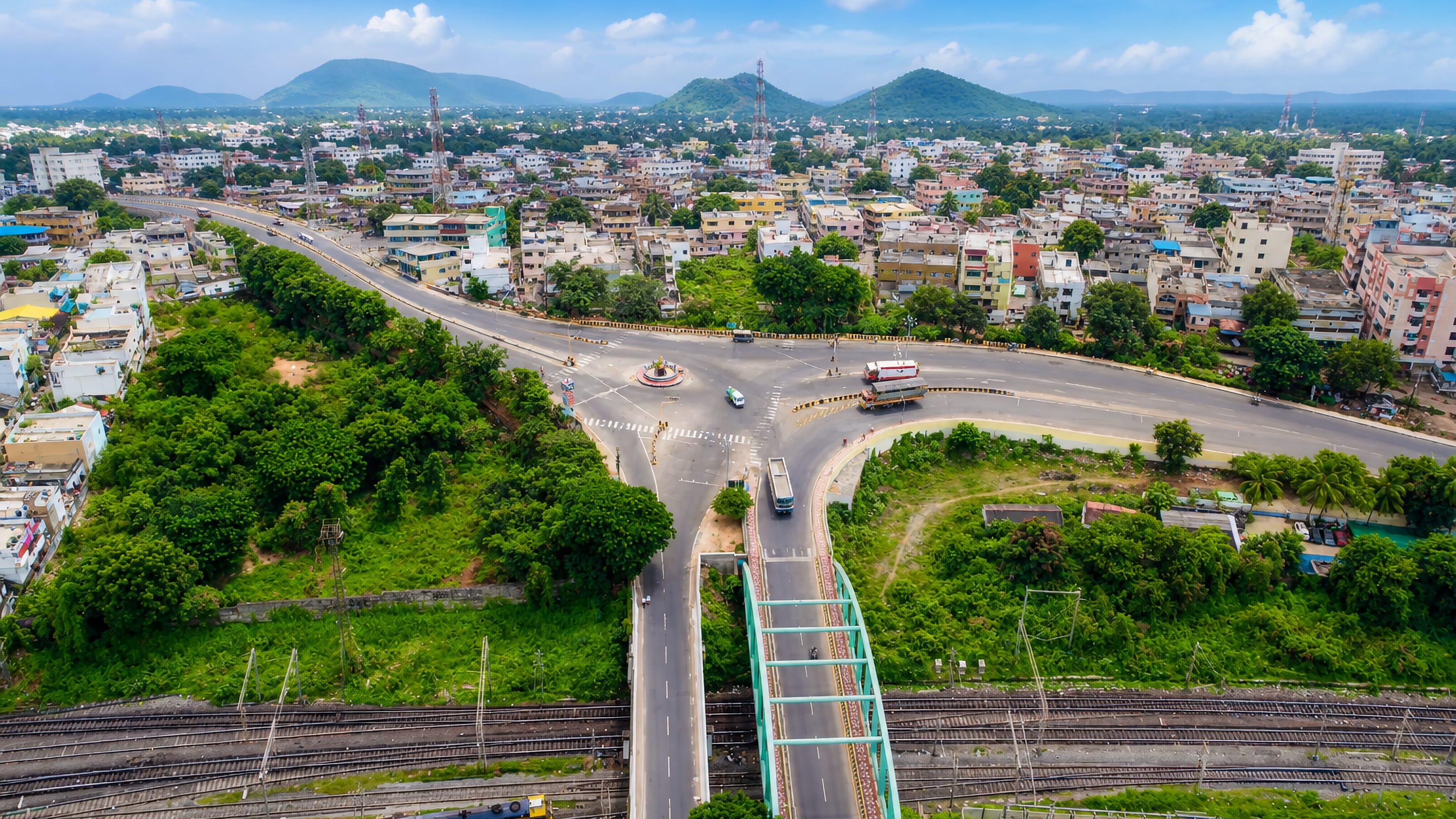 Aerial view of Vizianagaram, India, where a road overbridge crosses the railway beside a busy roundabout.
