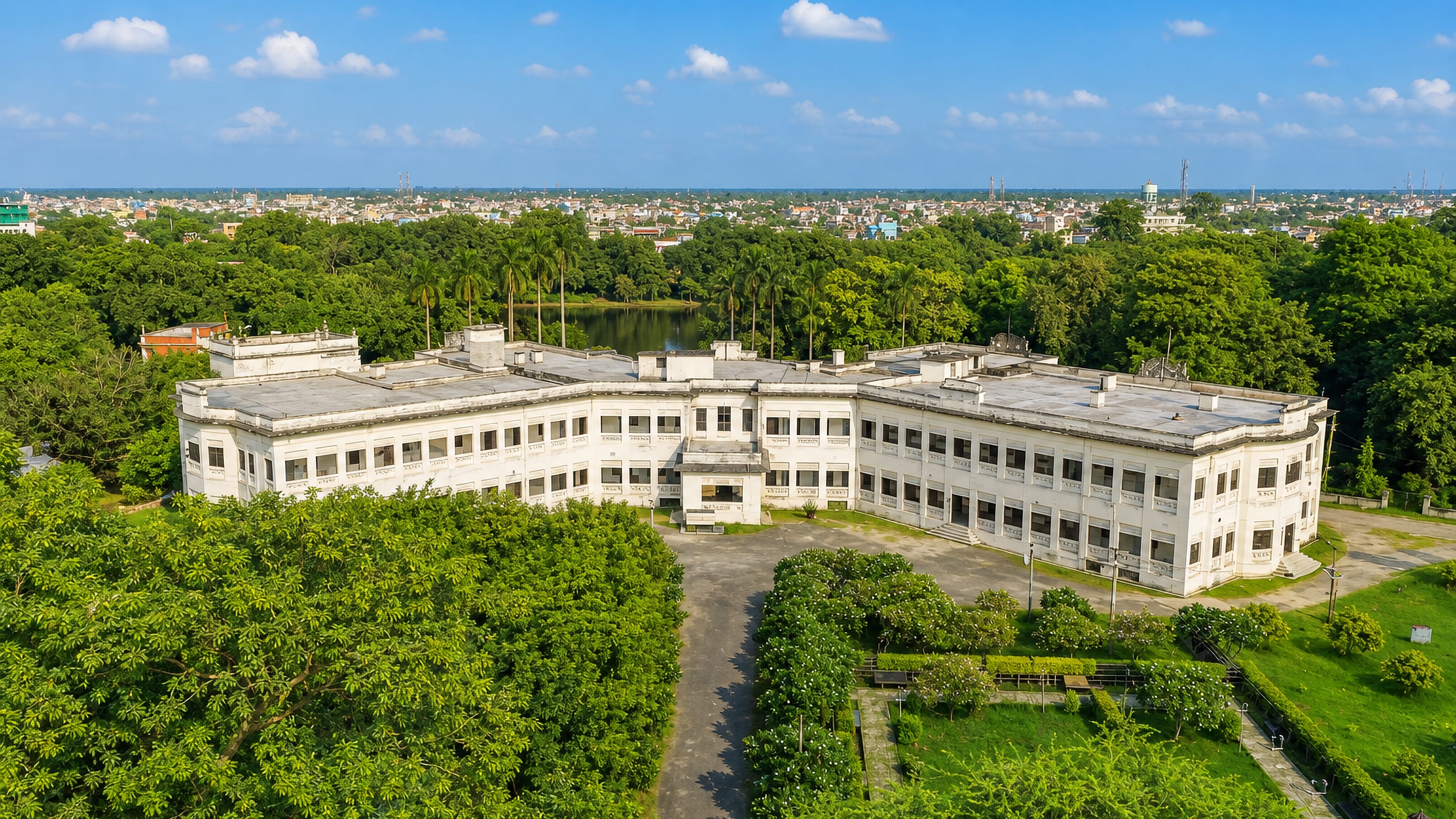 The white colonial-era Raj palace and wooded campus at Darbhanga, Bihar, with the city beyond.
