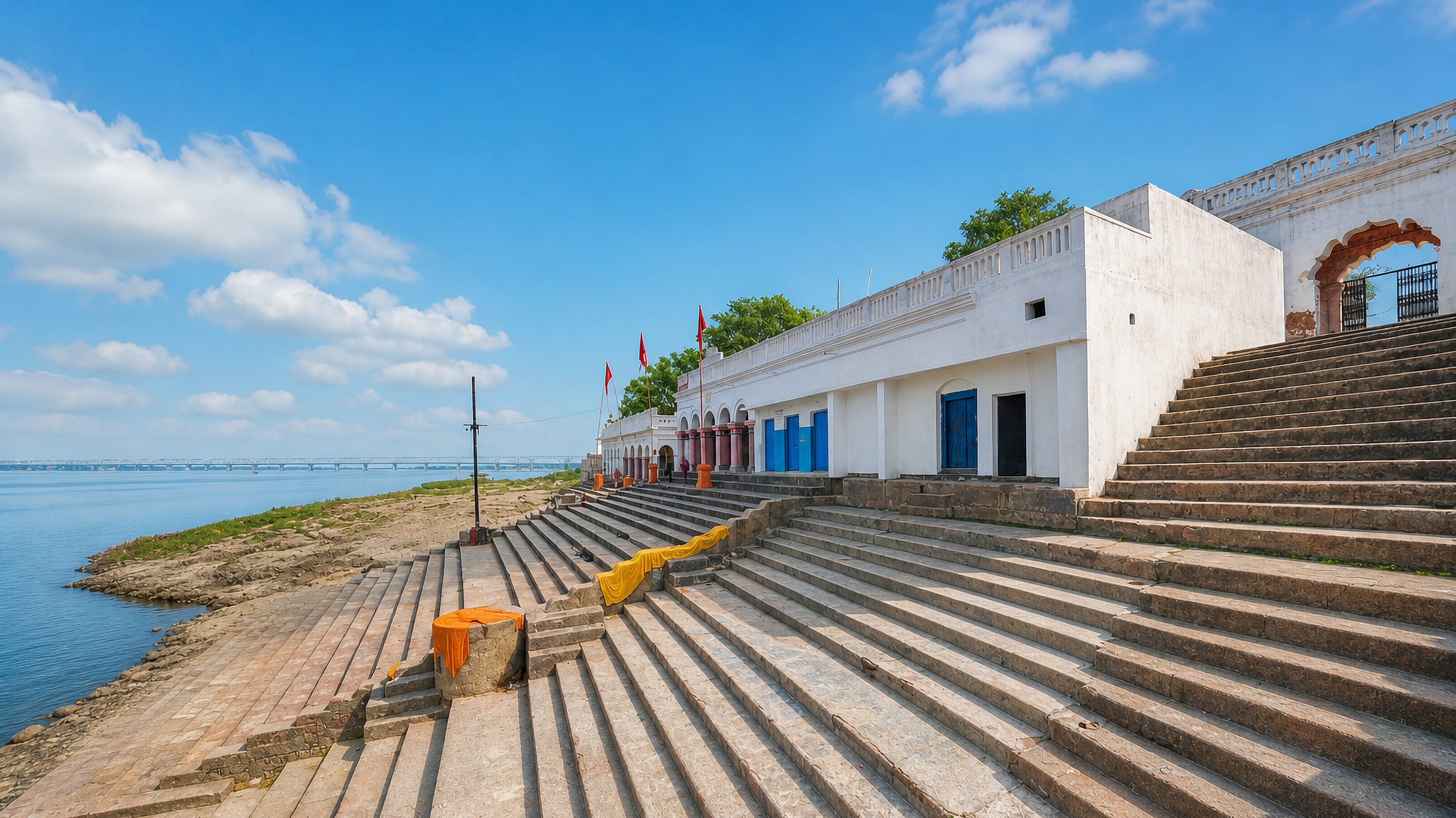 Stone ghat steps descending to the Ganges beside a whitewashed riverside temple in Munger, Bihar, India