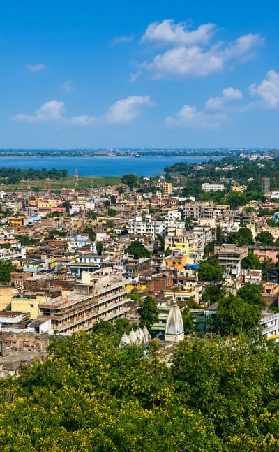 Aerial view of Ranchi's rooftops and temple spires with a lake in the distance