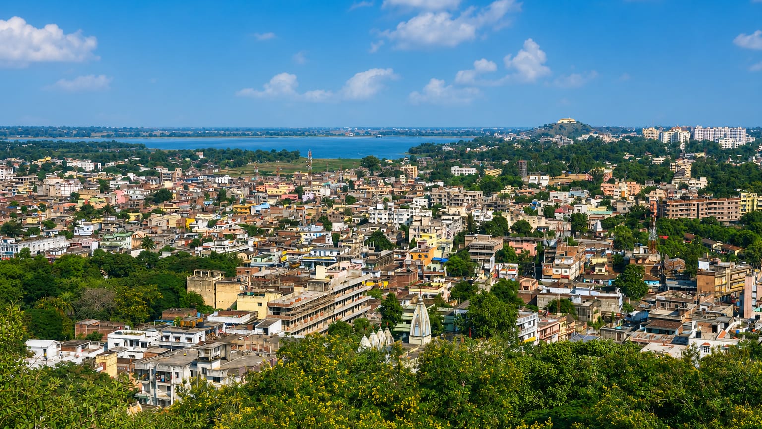 Aerial view of Ranchi's rooftops and temple spires with a lake in the distance
