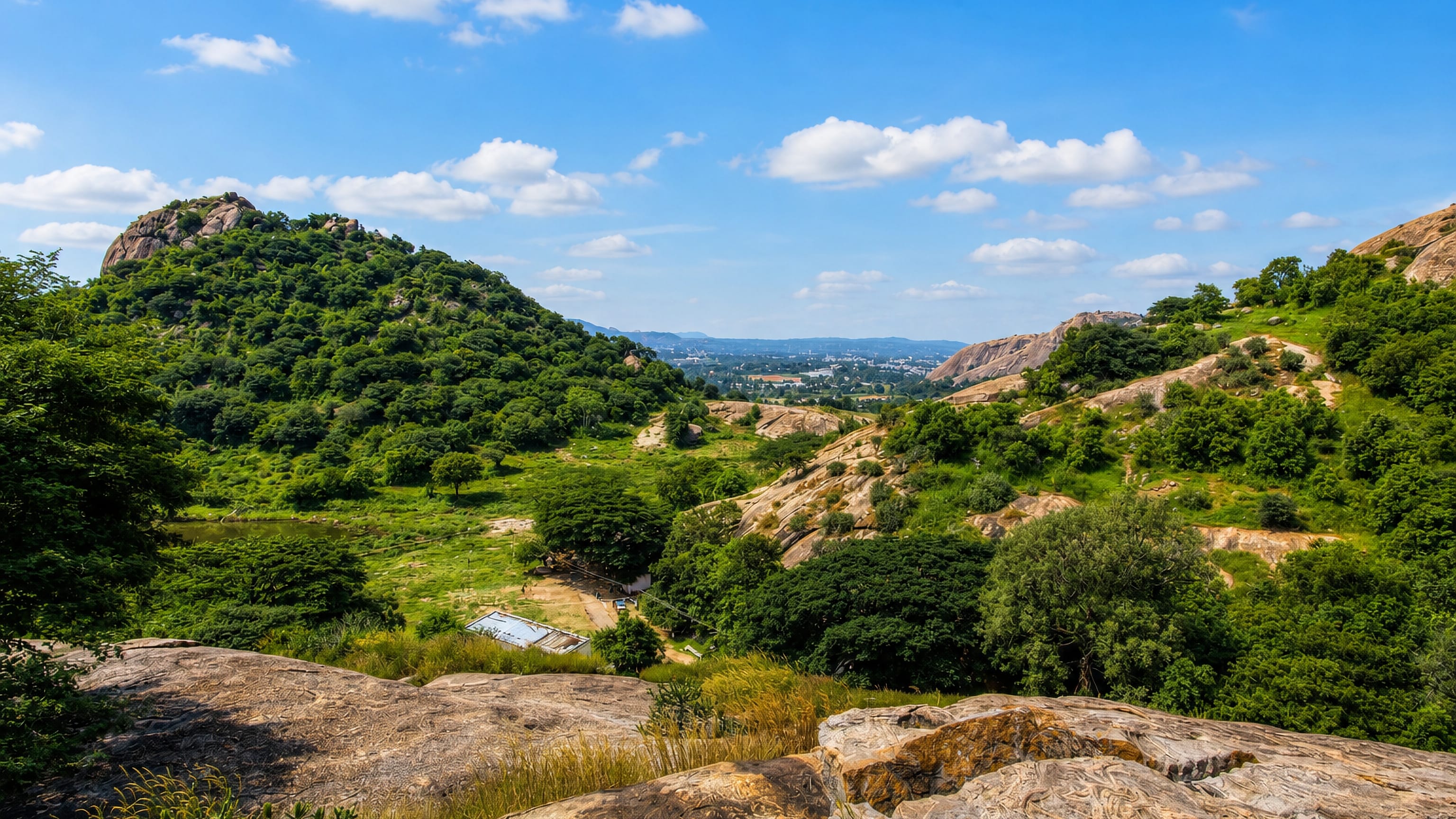 Granite hills and a green valley above Closepet (Ramanagara), Karnataka, with the town on the far horizon