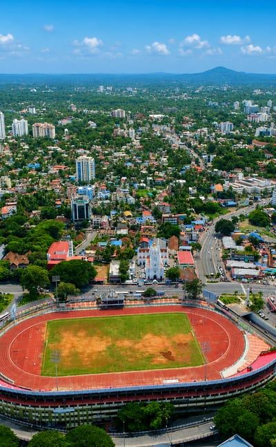 Aerial view of Thiruvananthapuram, India, over the oval Central Stadium and the lush low-rise city
