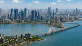 Aerial view of Mumbai's Bandra-Worli Sea Link bridge curving across the bay before the city skyline.