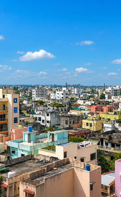 Rooftops of densely packed, colourful mid-rise buildings across Nagpur under a clear blue sky.